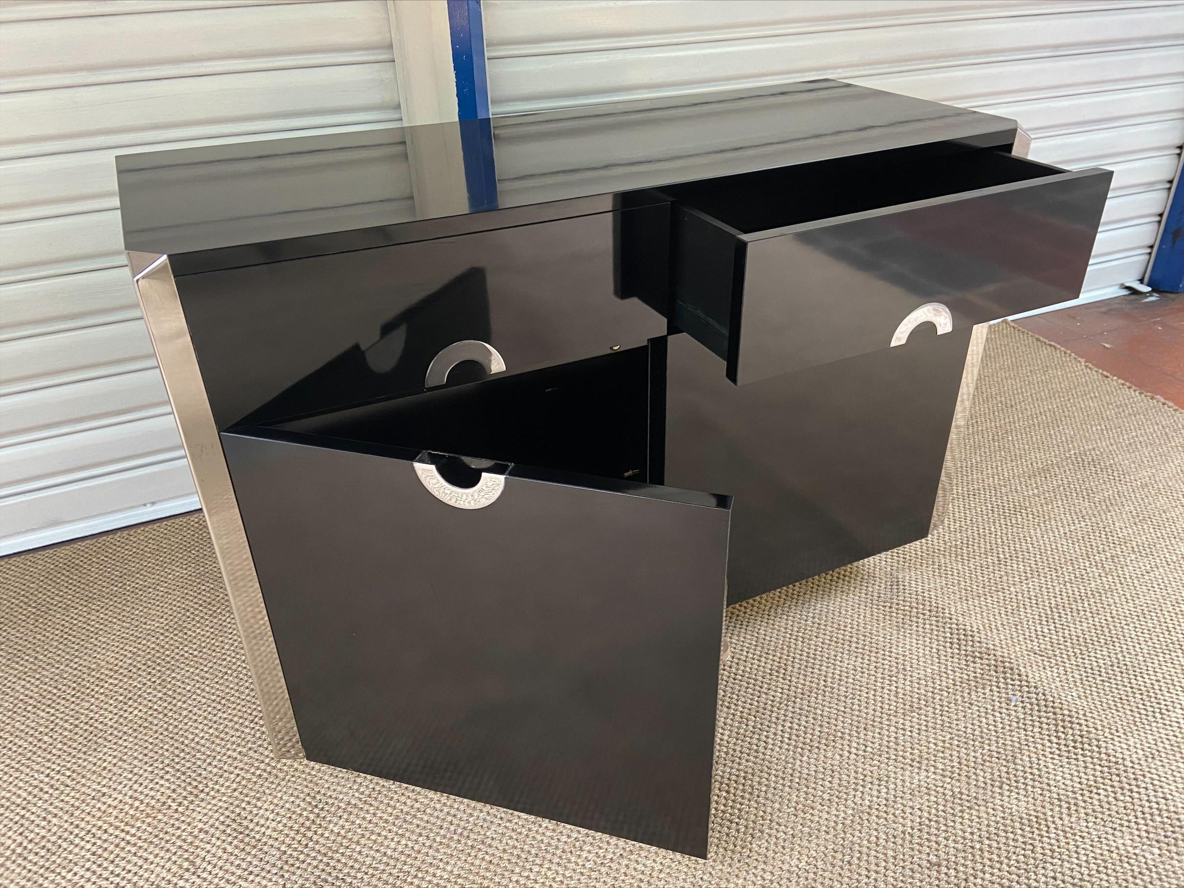Sideboard - Willy Rizzo for Pierre Cardin
Circa 1970
Black lacquered wood
Brushed steel finish: corners and handles.
Two drawers and two doors with interior shelf
H78 x W118 x D47.5 cm.

   