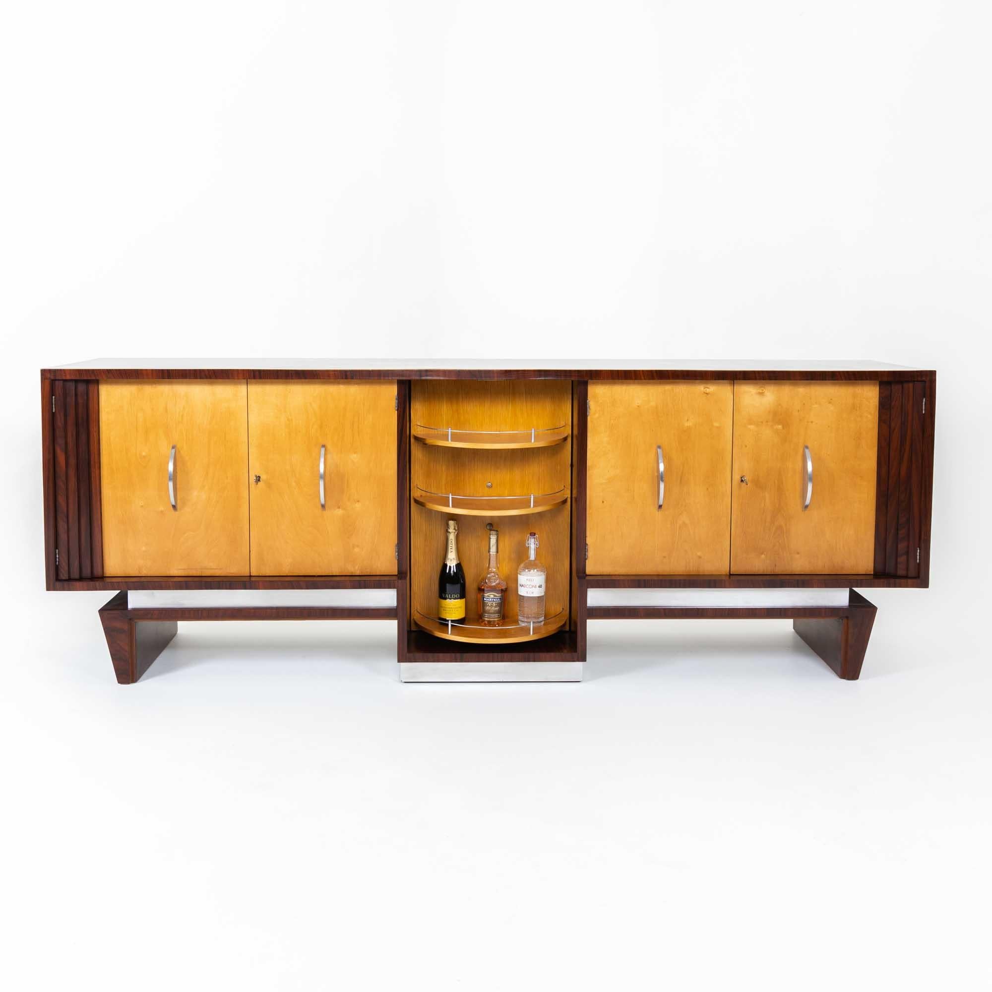 Large four-door sideboard designed by Franco Albini in the 1930s. The Art Deco sideboard is veneered on all sides and fitted with chrome half-moon handles and set off by means of vertical struts at the outer ends and the centre door. The doors are