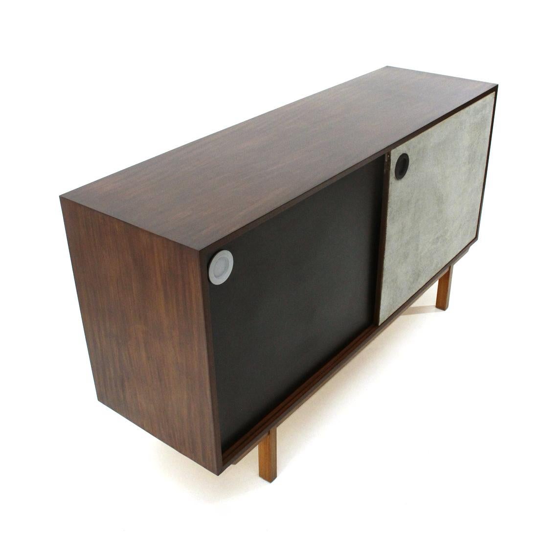 Italian-made sideboard produced in the 1960s.
Structure in veneered wood.
Two compartments with internal shelf.
Chest of 5 drawers and brass handle, first drawer with cutlery compartments.
Double sliding door:
A black ant veneer with a white