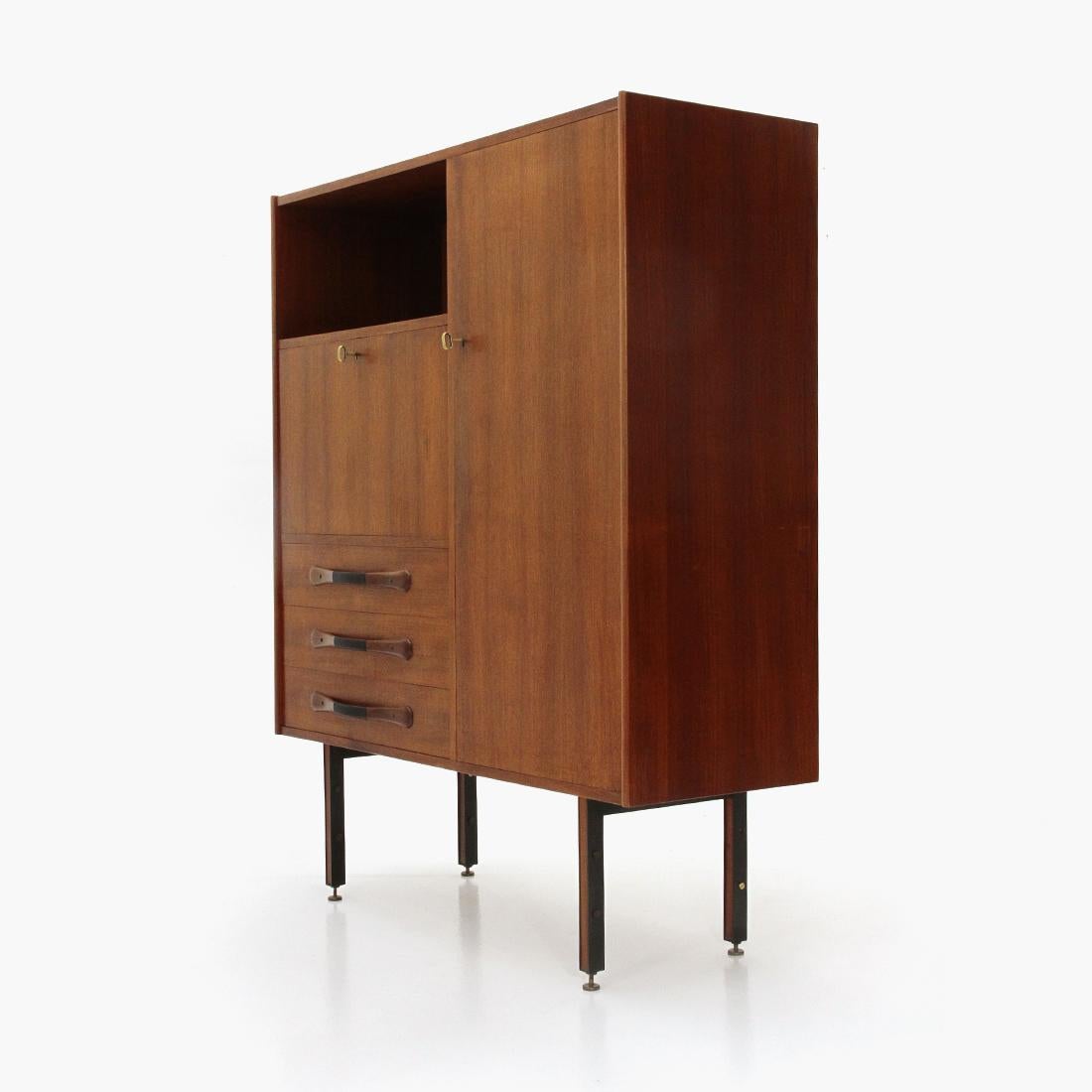 Sideboard of Italian manufacture produced in the 1960s.
Structure in teak veneered wood.
Three drawers with curved wooden handles with black stained rattan coating.
Open compartment.
Compartment with flap and internal shelf, closure with