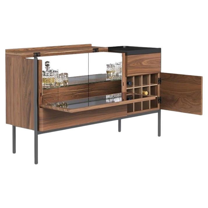 Ce buffet en noyer allie tradition et surprise. Inspirées par les boîtes à bijoux élégantes, ses lignes simples cachent une armoire à boissons sophistiquée derrière une surface réfléchissante, parfaite pour mettre en valeur vos bouteilles les plus