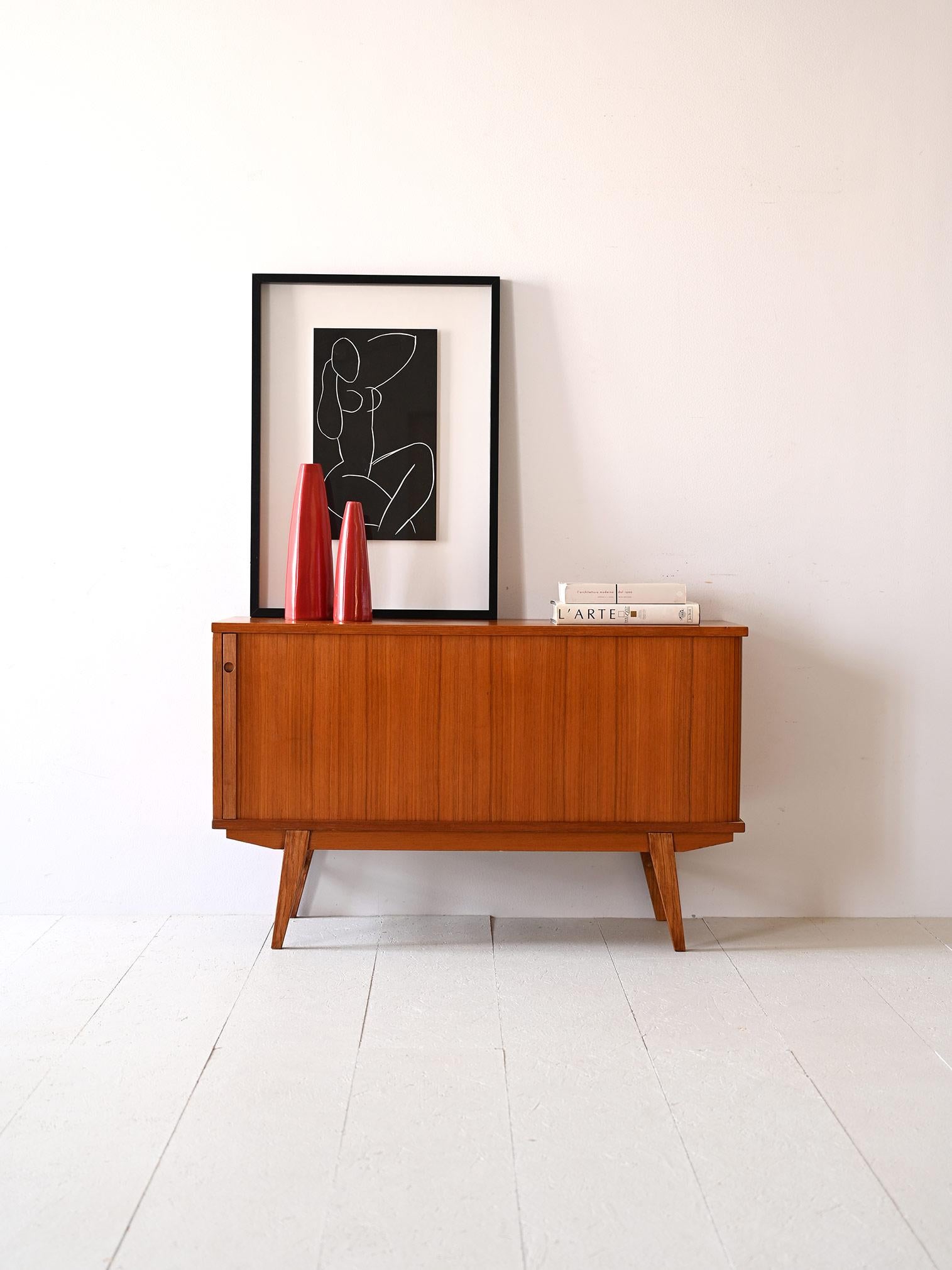 Scandinavian modernist sideboard.
 
Particular piece of Nordic design consisting of a compartment closed by a sliding shutter door.
A piece of furniture with modern lines and small dimensions, ideal for furnishing with style even rooms where space