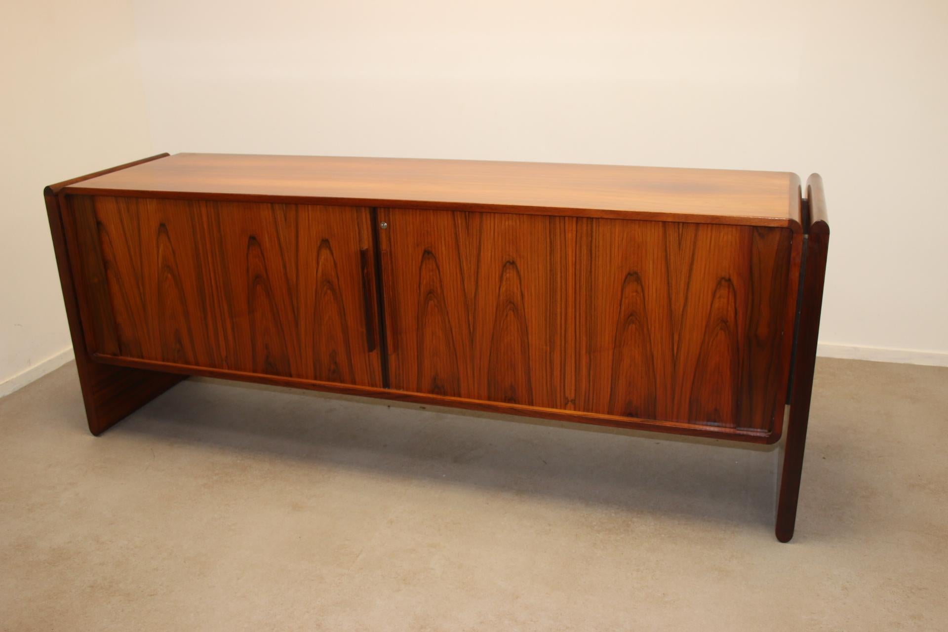 Sideboard with Roller Doors from Dyrlund - Vintage 1960s

Discover the timeless elegance of the teak sideboard with roller doors, manufactured by Dyrlund in the 1960s. This piece of furniture, made in the heart of Denmark, embodies the essence of