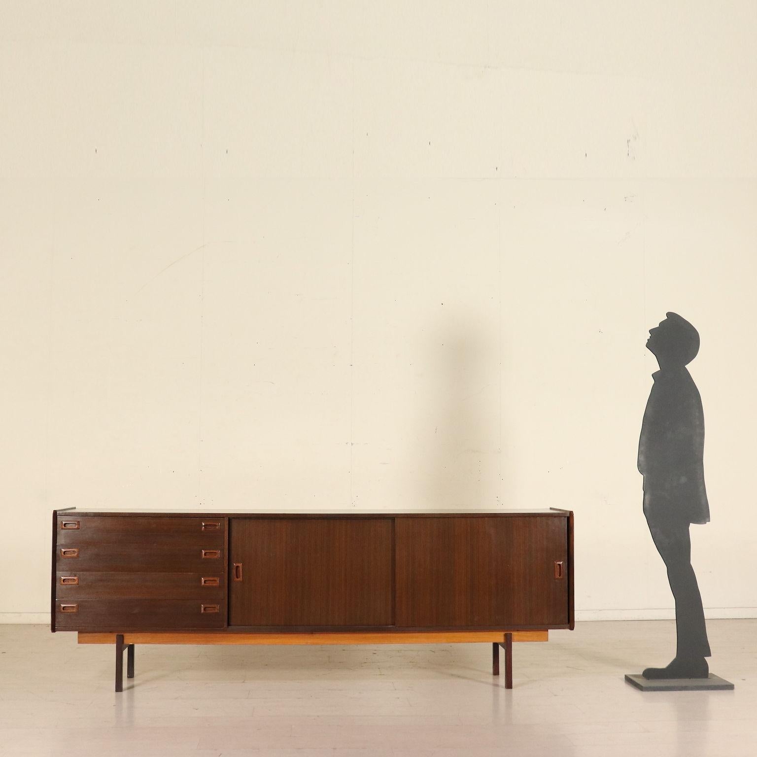 A sideboard with sliding doors and drawers; wood veneer. Manufactured in Italy, 1960s.