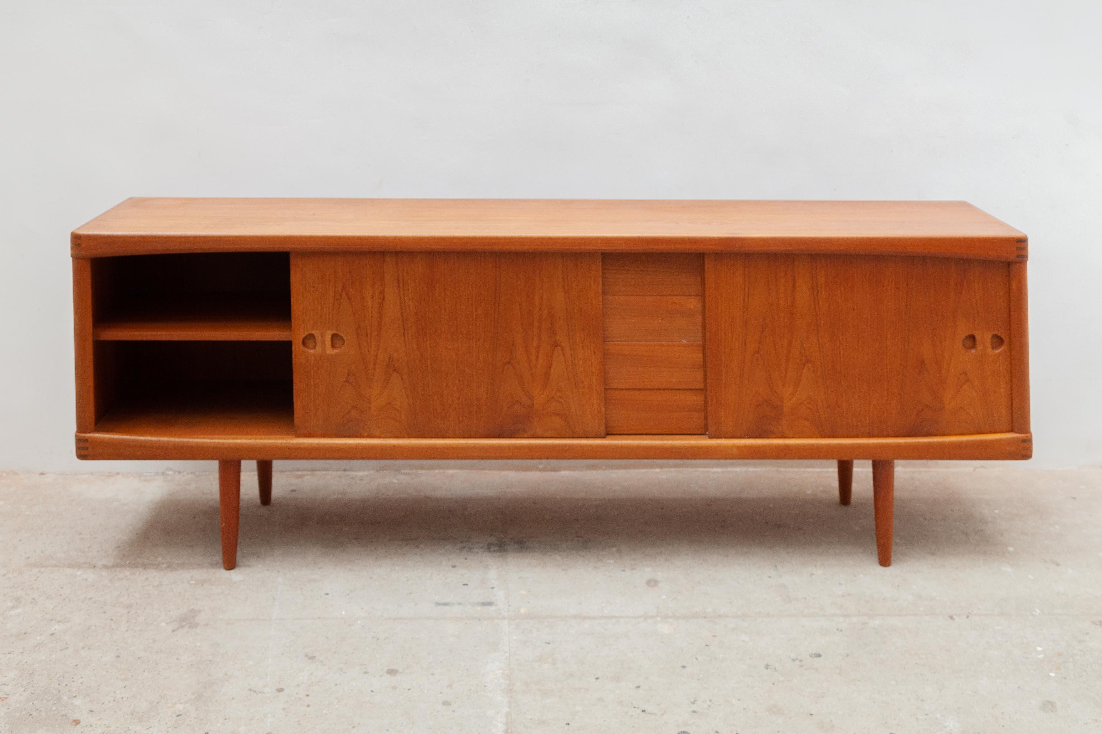 Sideboard high-quality cabinet in teak veneer with two sliding doors, four drawers, two shelves designed by H.W.Klein for Bramin his design are characteristic of the postwar Danish modern style, typically involving fine woods like teak and well