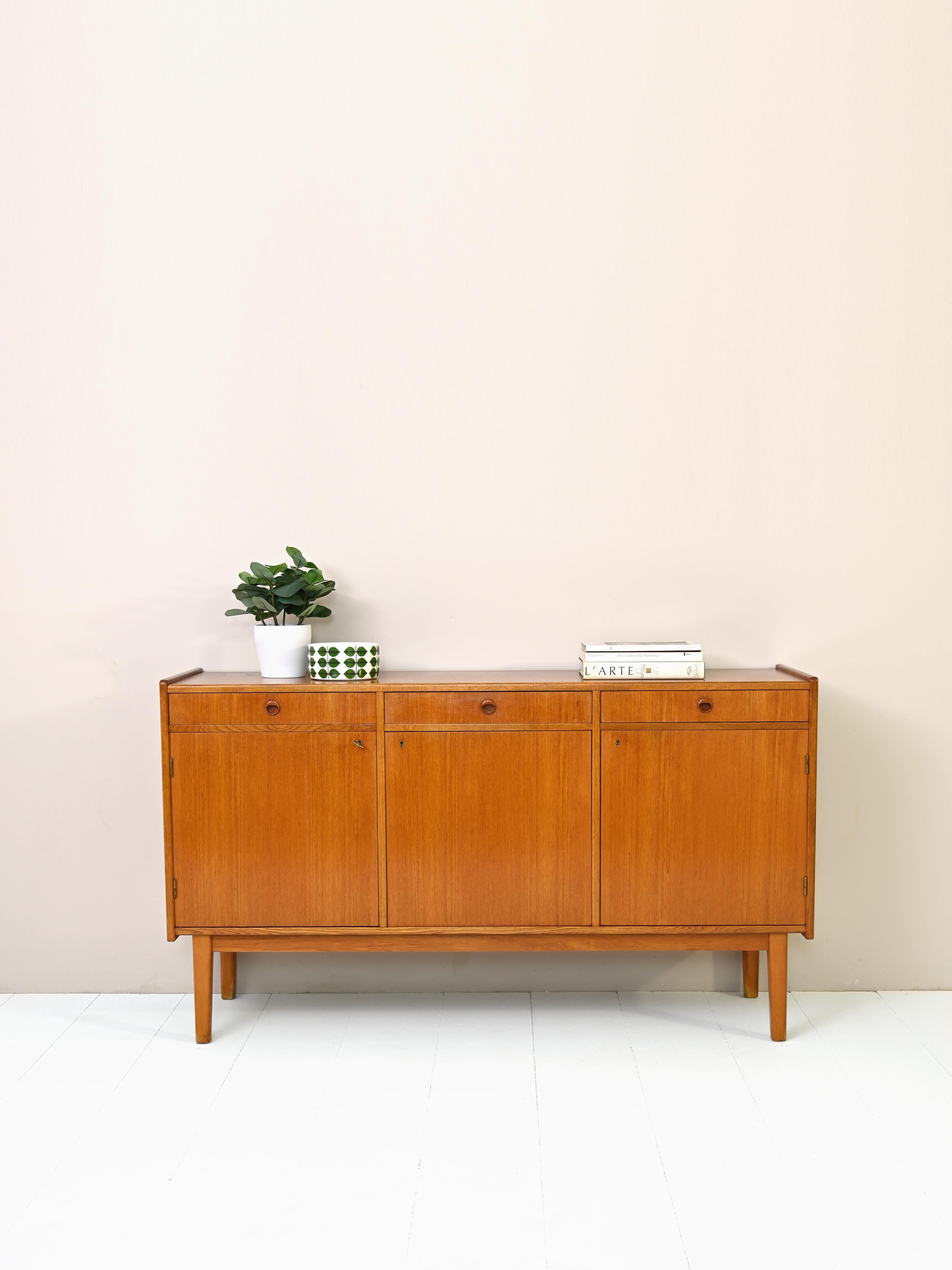 Original 1950s sideboard of Scandinavian provenance.
 
Divided into three equal parts consisting of a drawer under which is a compartment equipped with a shelf.

Swedish craftsmanship is evidenced in the attention to detail.

The square,