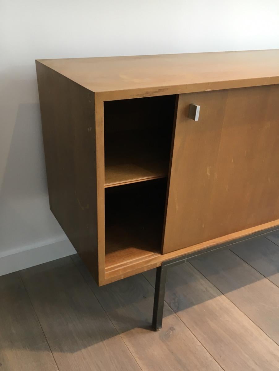 This nice sideboard is made of natural oak with a black lacquered door on a black steel base. It has two sliding doors and a bar. This is a French work, circa 1950.
 