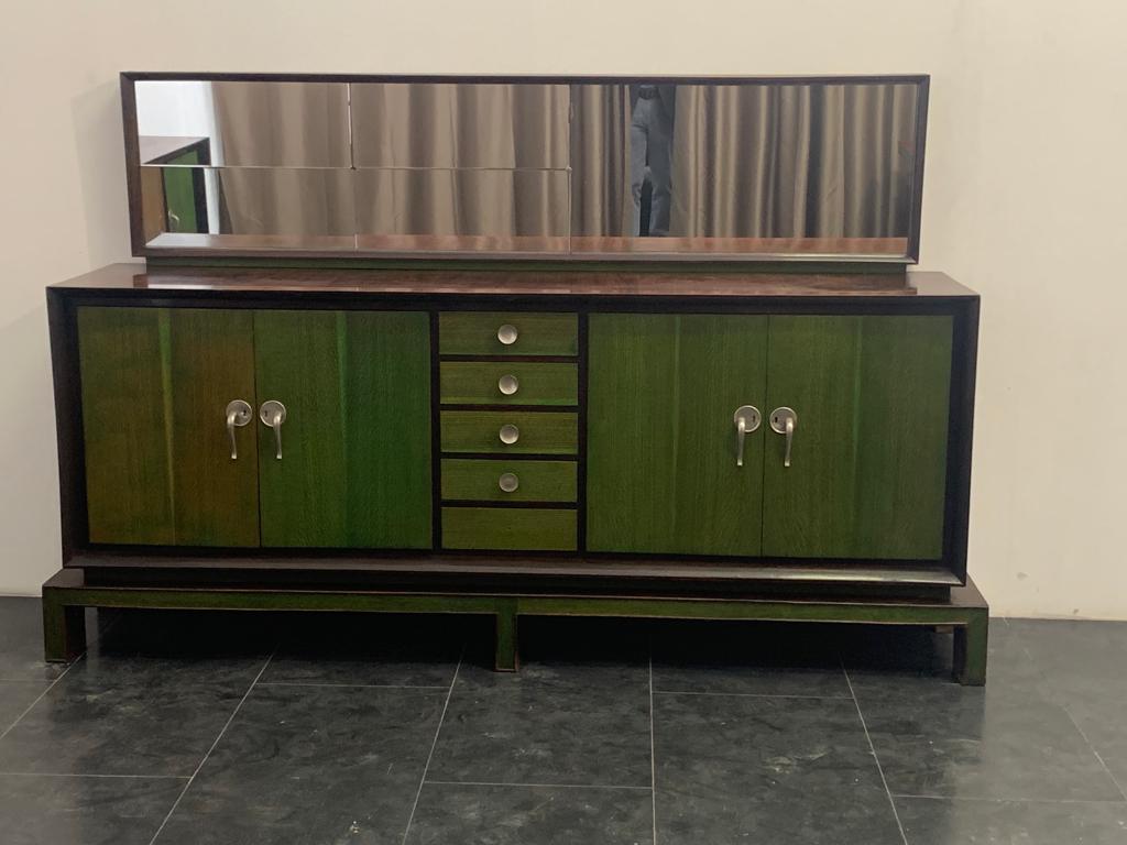 Exceptional and unique art deco rationalist sideboard with mirror. Rosewood veneered body on the front flared frame in solid rosewood accommodates central drawers and maple side doors finished with green aniline. Futurist-style handles are in satin