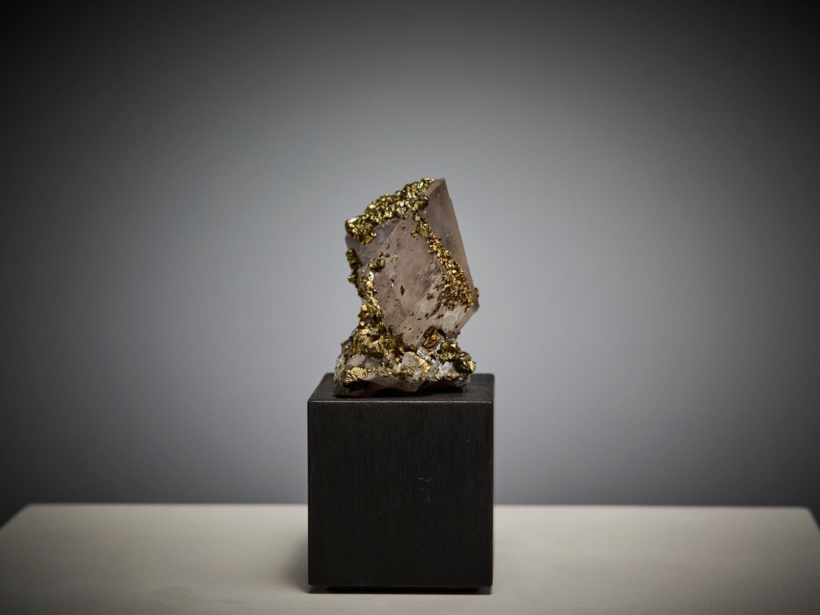 This elegant specimen from China showcases stacked cubic crystals of siderite, arranged in a sculptural, geometric formation. The composition is beautifully enhanced by a delicate layer of golden pyrite that rests across the upper surfaces, adding