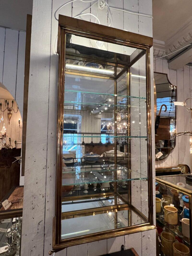 Schöner und eleganter Schaukasten von SIEGEL-PARIS. CIRCA 1930er Jahre, strenger Art-Déco-Stil mit glatten und starken Profilen.

Ein hochwertiges Stück aus Messing, mit 3 schönen Glasböden, verstellbaren Regalhaltern und verspiegeltem Glas auf dem