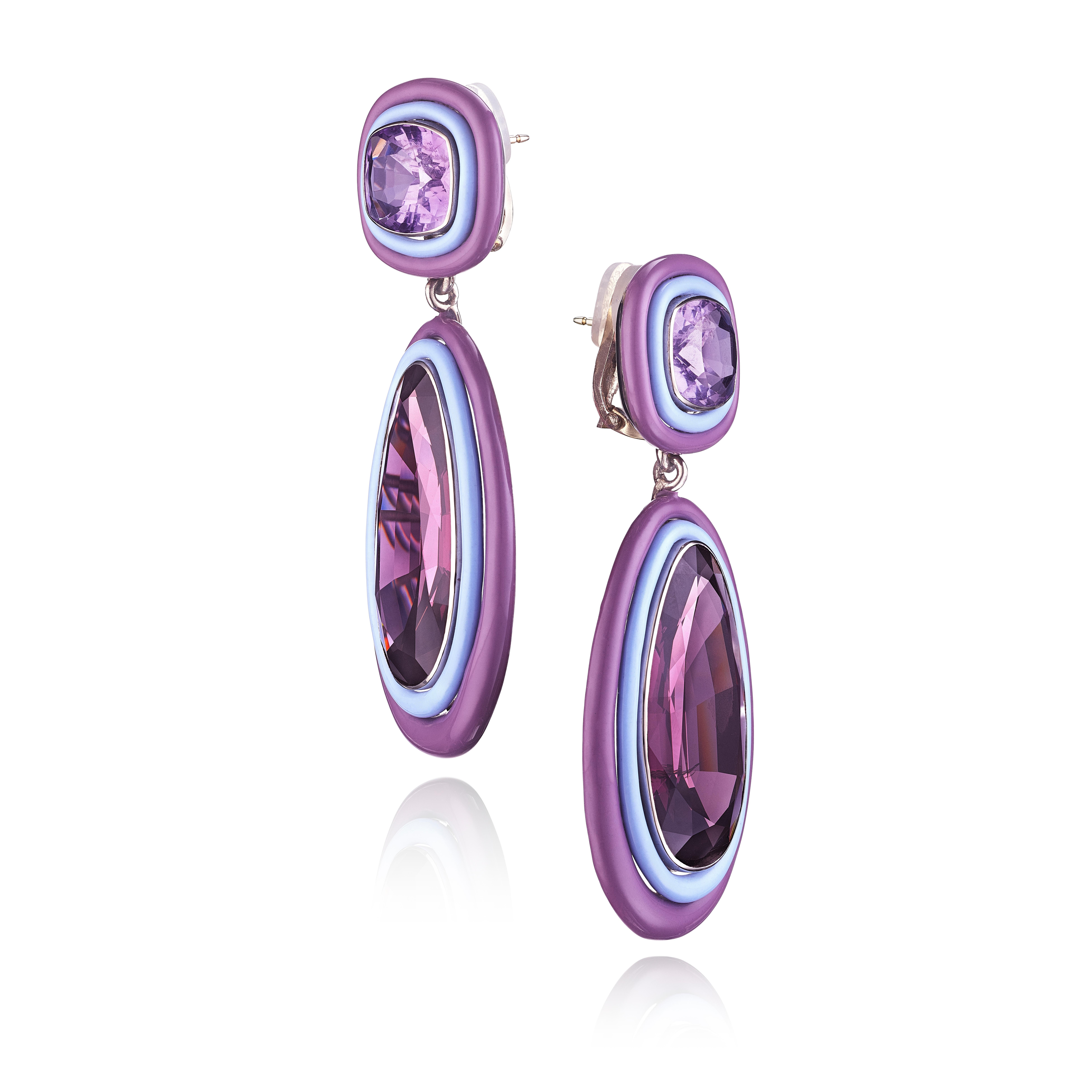 A pair of ear clips, each featuring a pear-shaped spinel framed in varying shades of purple-colored ceramic, suspended from a similarly framed cushion-shape amethyst; mounted in white gold
• 2 pear-shaped spinels, weighing 36.72 and 35.80 carats
• 2