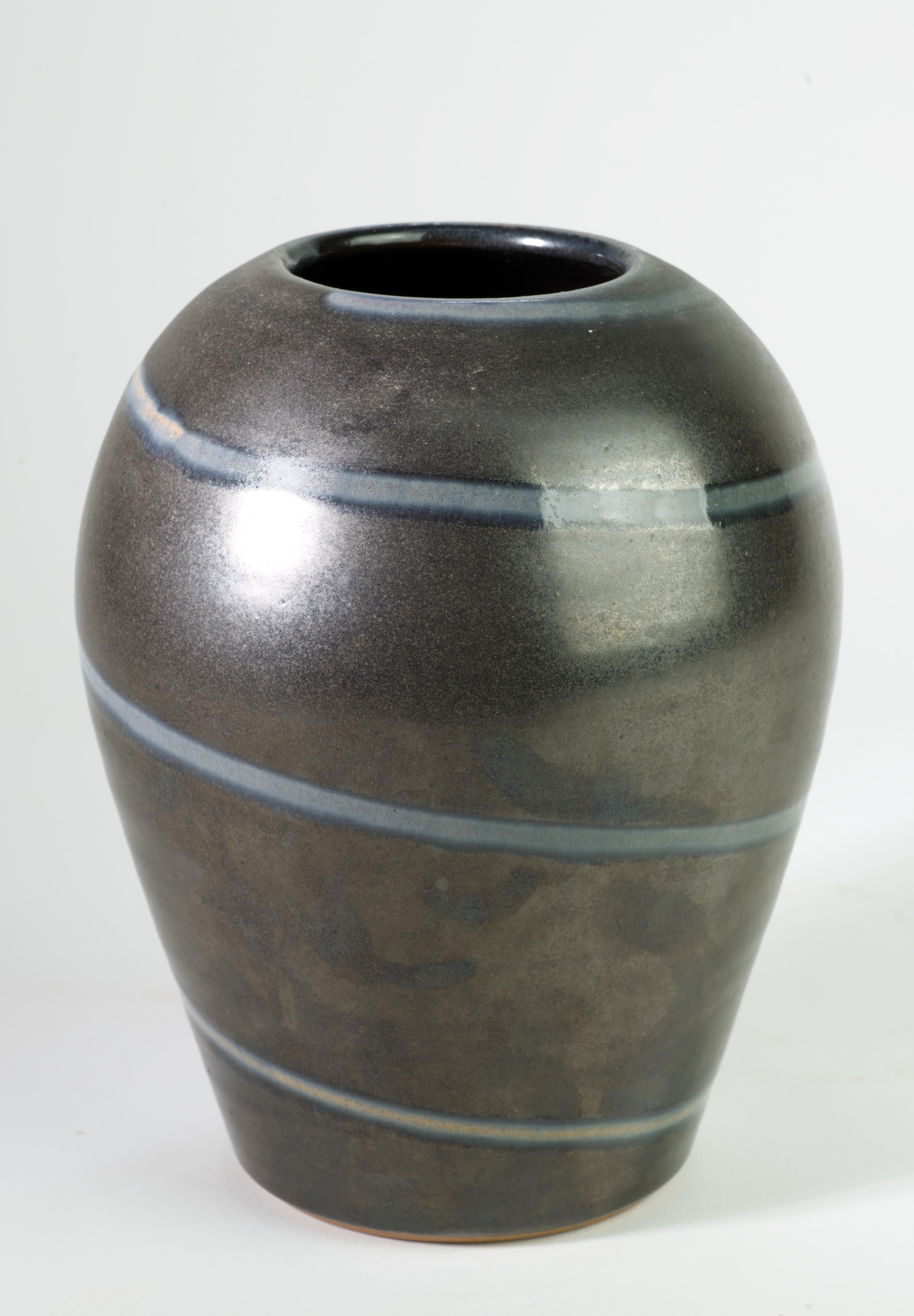  Raro vaso in ceramica fatto a mano con un decoro grafico astratto e minimale di spirali di smalto lucido beige e blu su un complesso sfondo di smalto grigio semi-opaco, disegnato negli anni '50 da Siegfried Gramann per Töpferhof Römhild.

Il vaso è