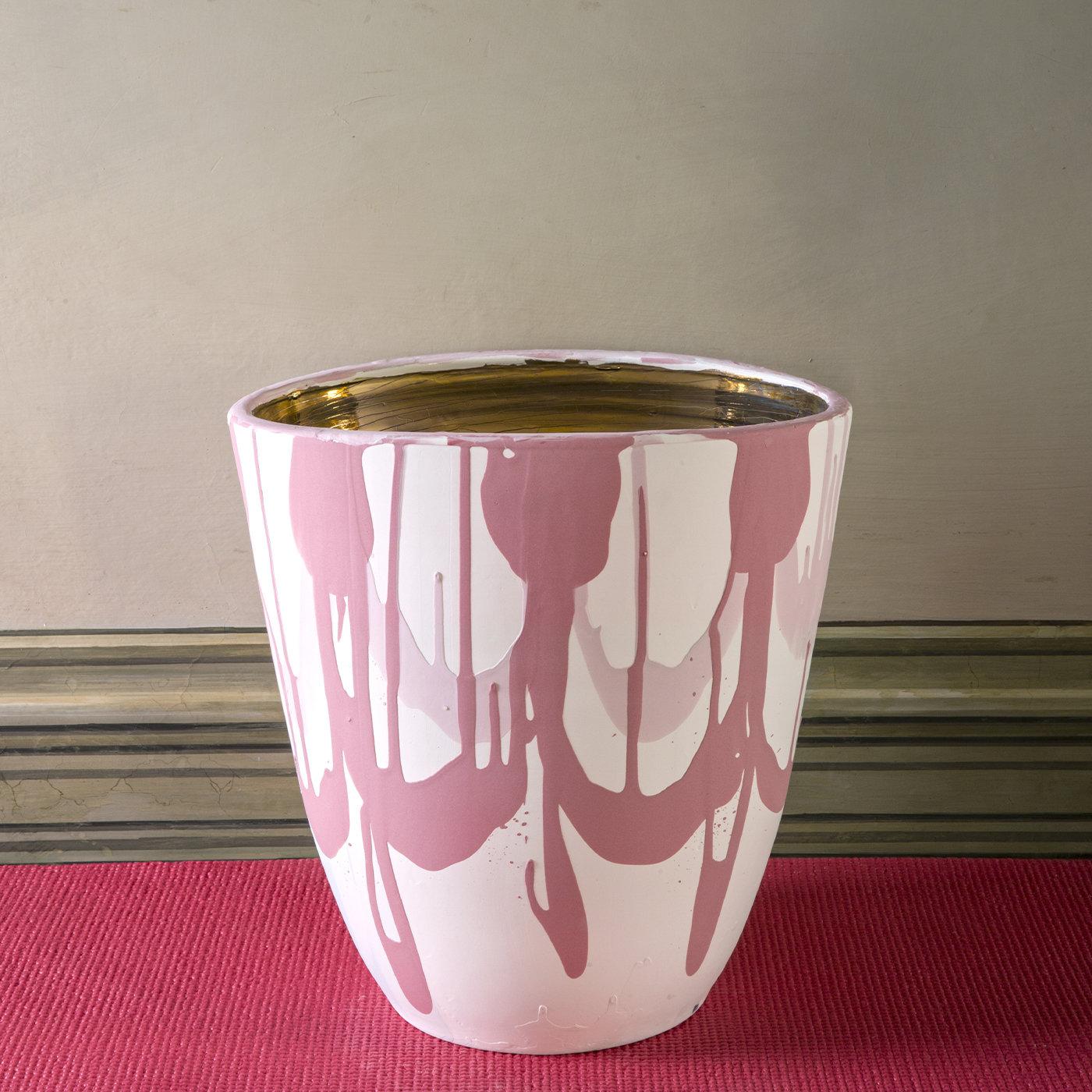 This vase features a stunning opaque slipware exterior whose decorations resemble the flourishes on a Neoclassical vase. Delicate yet dynamic pink brushstrokes run across its white surface. The interior is entirely in lustrous gold. The item has a