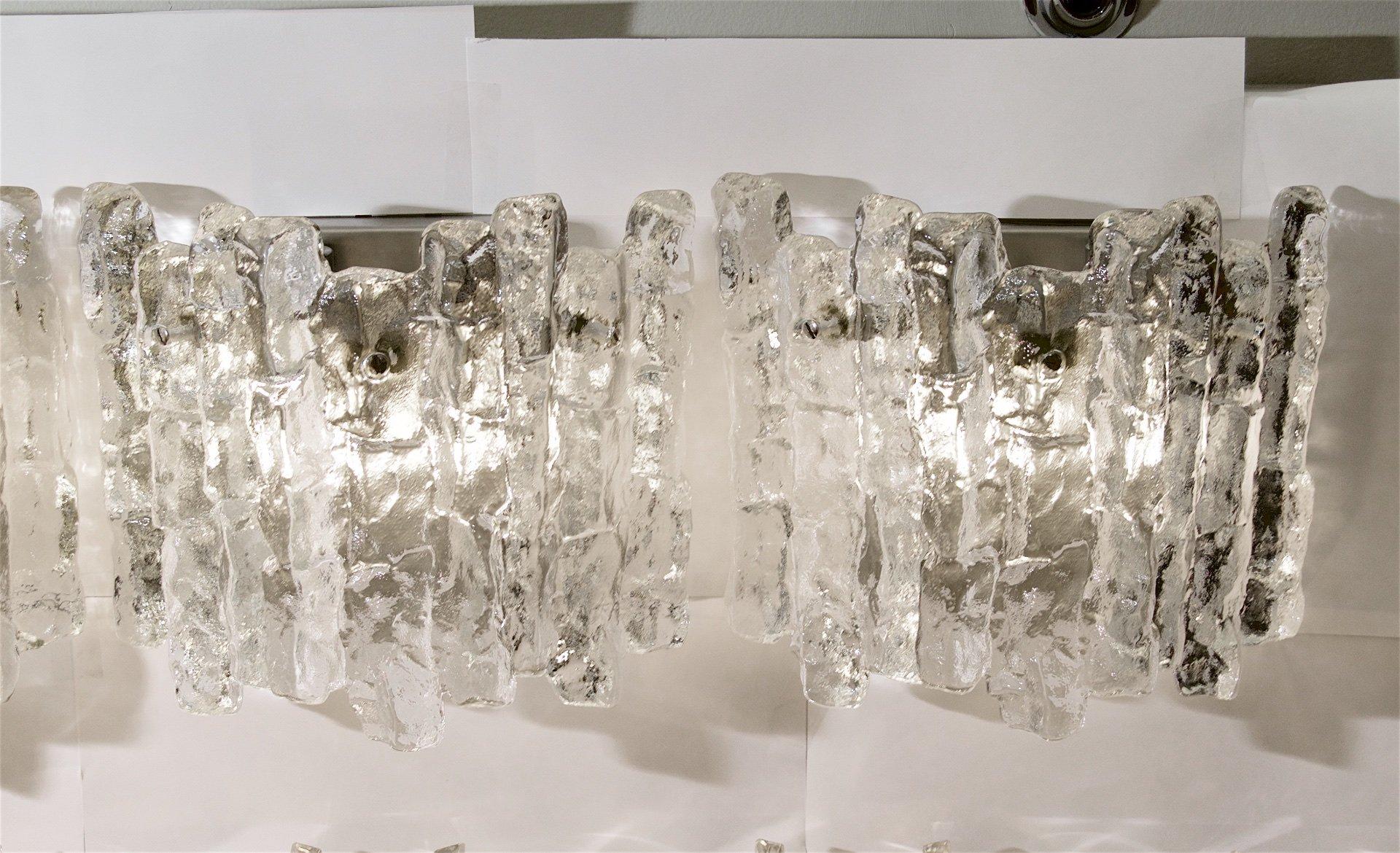 Kalmar Franken KG
Österreich, 1960er Jahre

Hervorragende Kalmar-Eisglas-Wandleuchter mit jeweils drei schweren Eisglasstücken.

Für jeweils zwei E-14-Glühbirnen mit bis zu 40 Watt pro Glühbirne, abgebildet mit 10-Watt-Glühbirnen. Neue