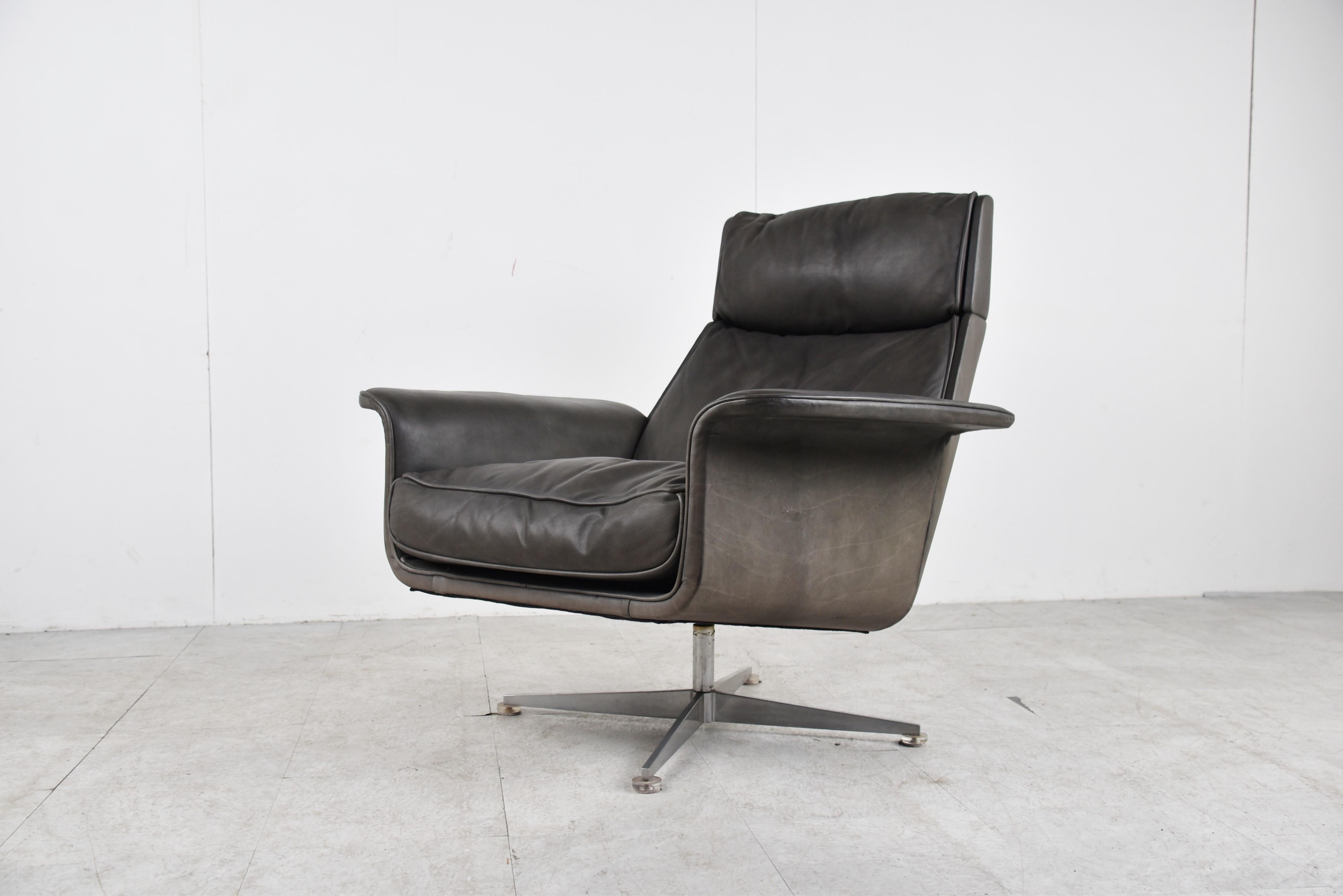 Mid-century grey leather swivel chair designed by Jacques Brule for Hans Kaufeld.

One of the most comfortable chairs we ever sat in, complete with foot stool.

Attractive timeless design, all covered in quality grey leather.

Chromed 4 legged