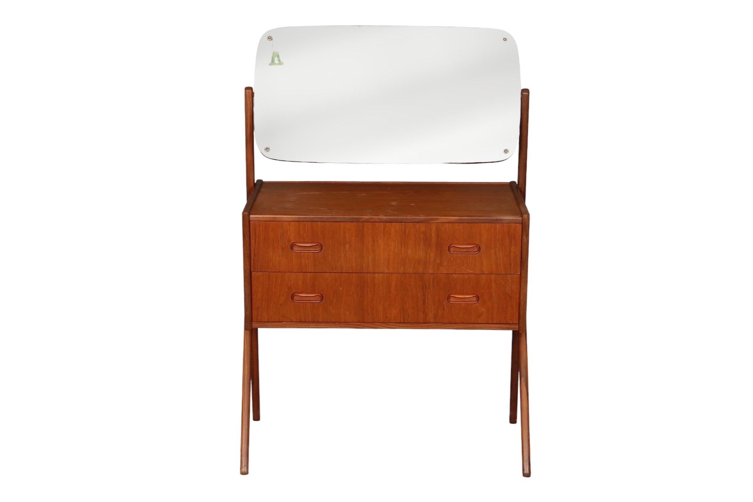 A 1960’s Danish Y-leg vanity with mirror in the style of Sigfred Omann for Olholm Mobelfabrik. Made of teak with two dovetailed drawers that open with recessed handles.

Measures: W27” x D14.5” x H42” with mirror 
Dresser height: 26.5”