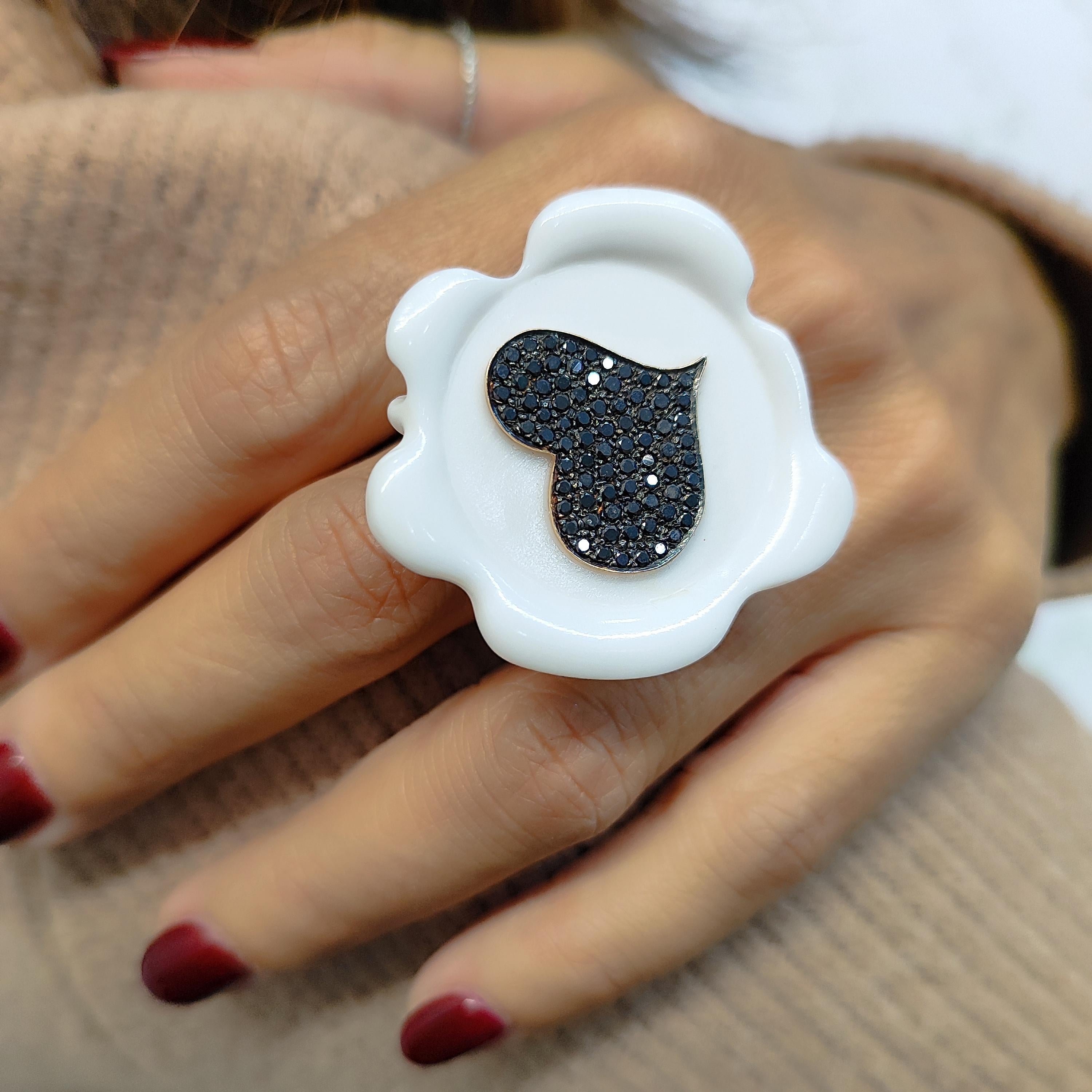 The Sigillo Ring is a unique and contemporary piece crafted with the finest materials. It features an 18K gold heart adorned with black diamonds, adding a touch of luxury and sophistication to the Corian. The standout element of this ring is the