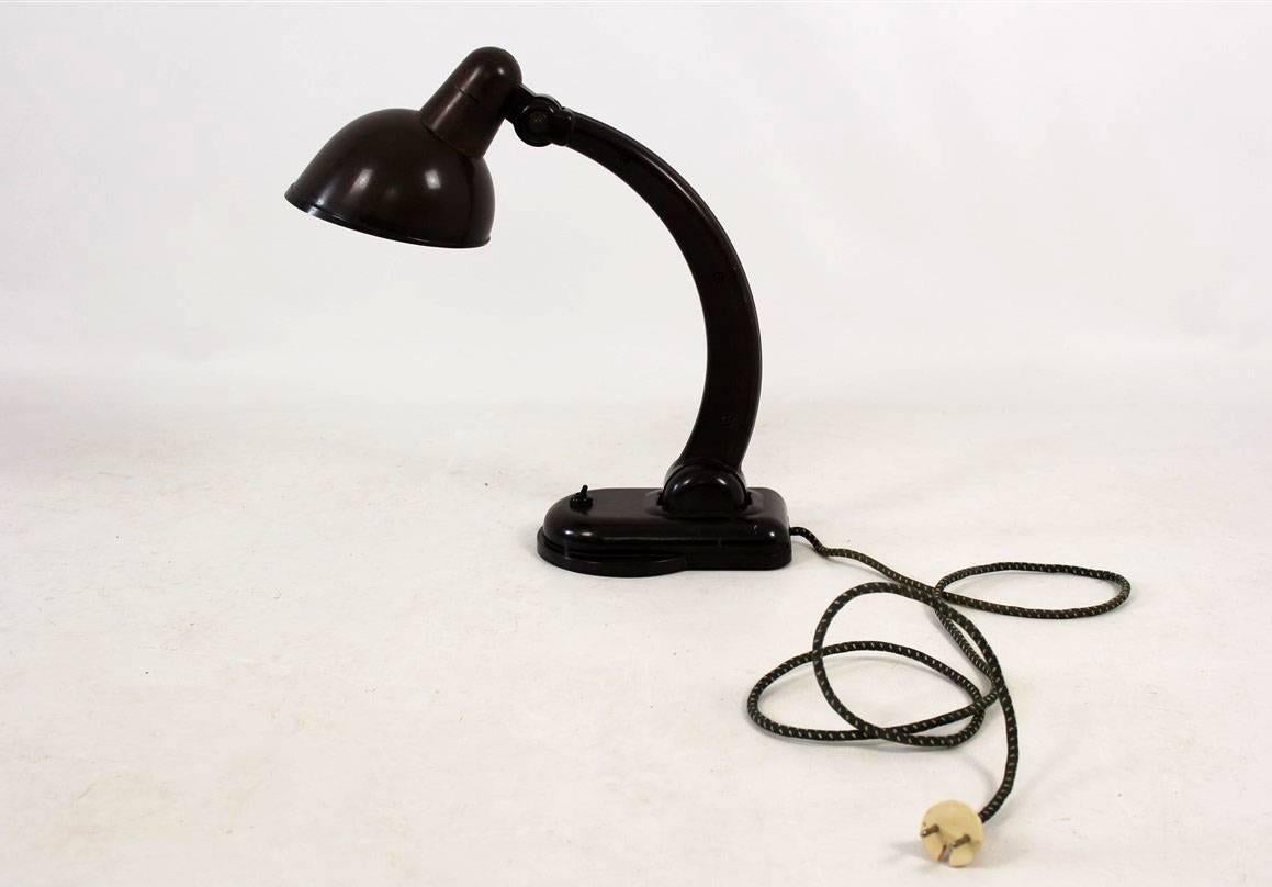 This bakelite table lamp, model Sigma, was designed by Christian Dell for Heinrich Römmler AG in the 1930s.
It is signed, from the bottom visible coded manufacturer’s mark used in those times.
Features adjustable lampshade and the inclination of