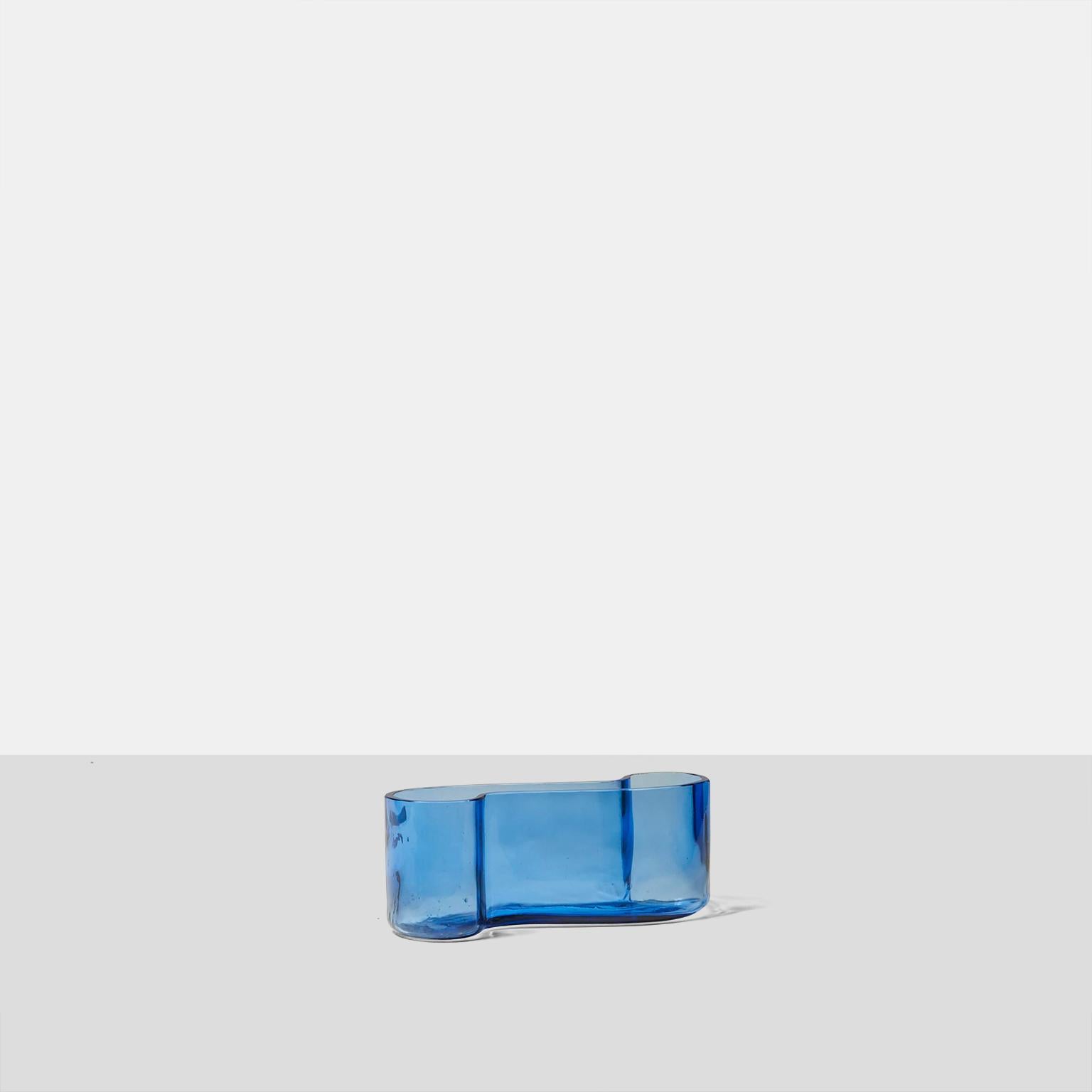 Una ciotola a forma di sigmoide in vetro blu zaffiro, realizzata da Monica Bratt per Holmgaard Glass. Il vetro ha una finitura strutturata dovuta al processo di produzione. 

Una piccola imperfezione sul lato inferiore, altrimenti coerente con l'età