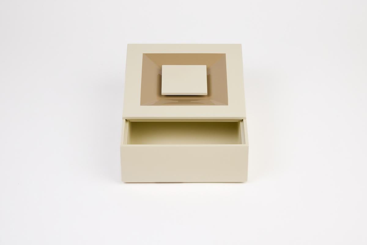 Minimalist, precious, distinctive. The SIGN BOX collection features a tray, two square boxes, and one rectangular box, available as a set or individually. Each box stands out with a seamlessly integrated handle, flush with the lid, revealing a