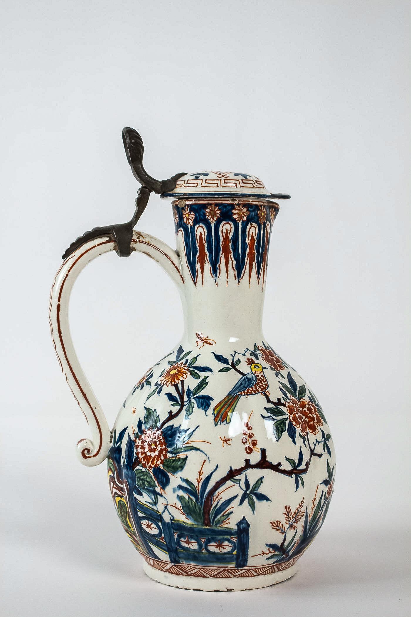 Sign CK, Rare delft Polychrome Faience Pitcher, circa 1700

A rare delft faience pitcher with polychrome decorations of birds, flowers, barriers, clouds, and insects. Our pitcher has the particularity of being complete, with its pewter hinge
The