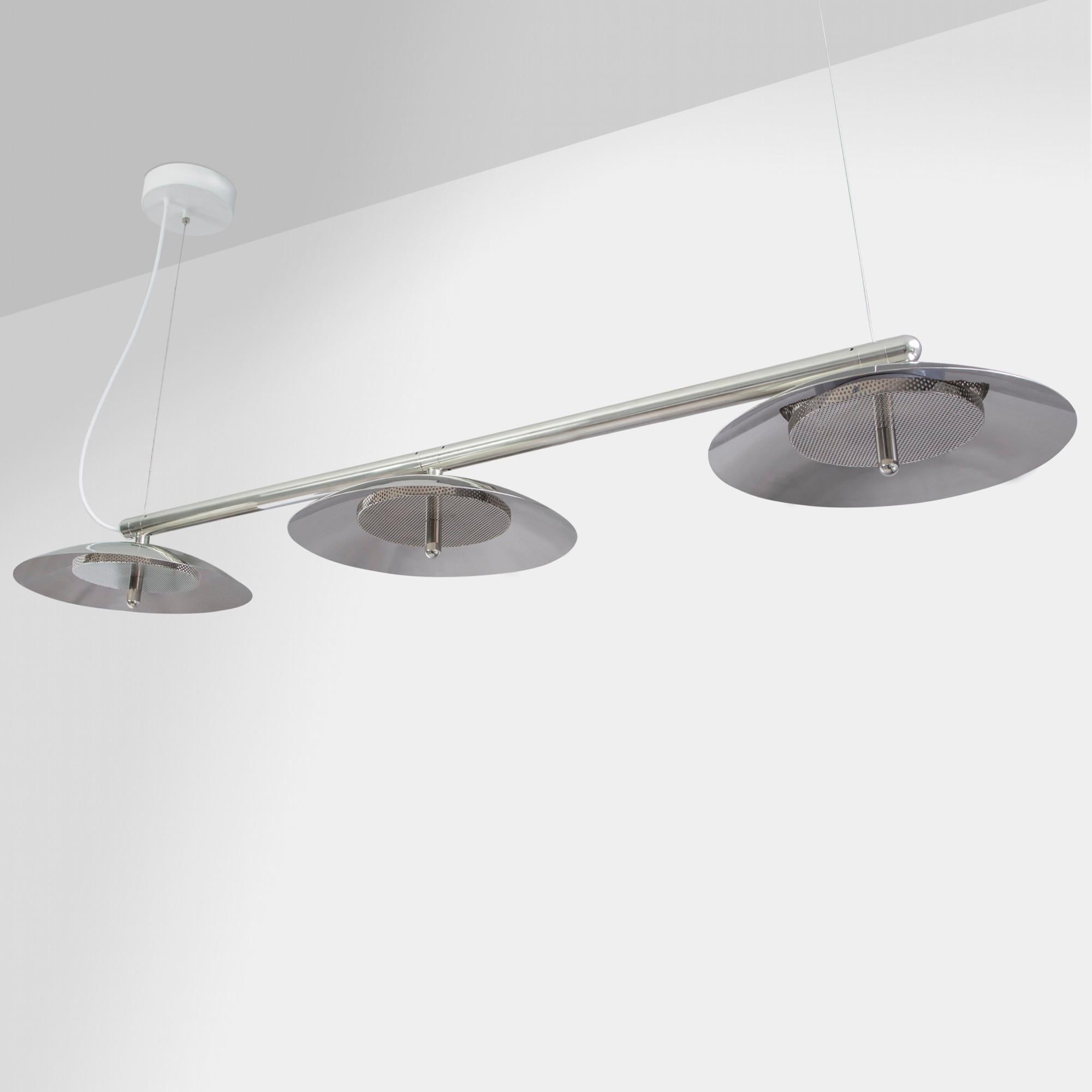 Parfait au-dessus d'une table à manger ou d'une table de conférence, le Signal Linear Pendant est une suspension linéaire résolument moderne. Un bras en métal poli soutient sans effort des abat-jour en métal filé qui diffusent une lumière vers le