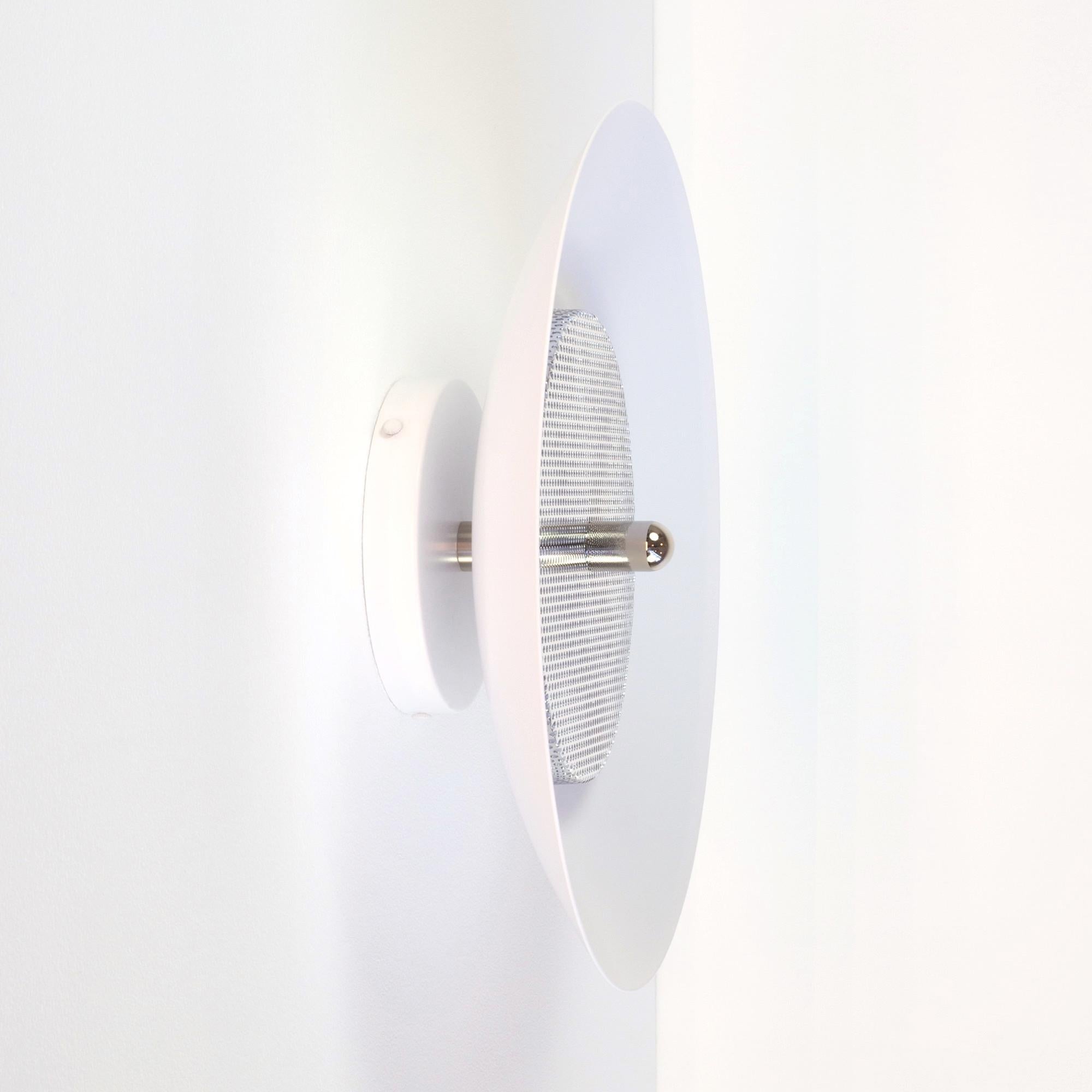 Applique moderne o da incasso. Composta da un paralume in metallo filato che riflette la luce filtrata da un diffusore in metallo perforato, il sottile calore dell'applique di segnale è perfettamente bilanciato dalla sua forma sorprendente. Con le