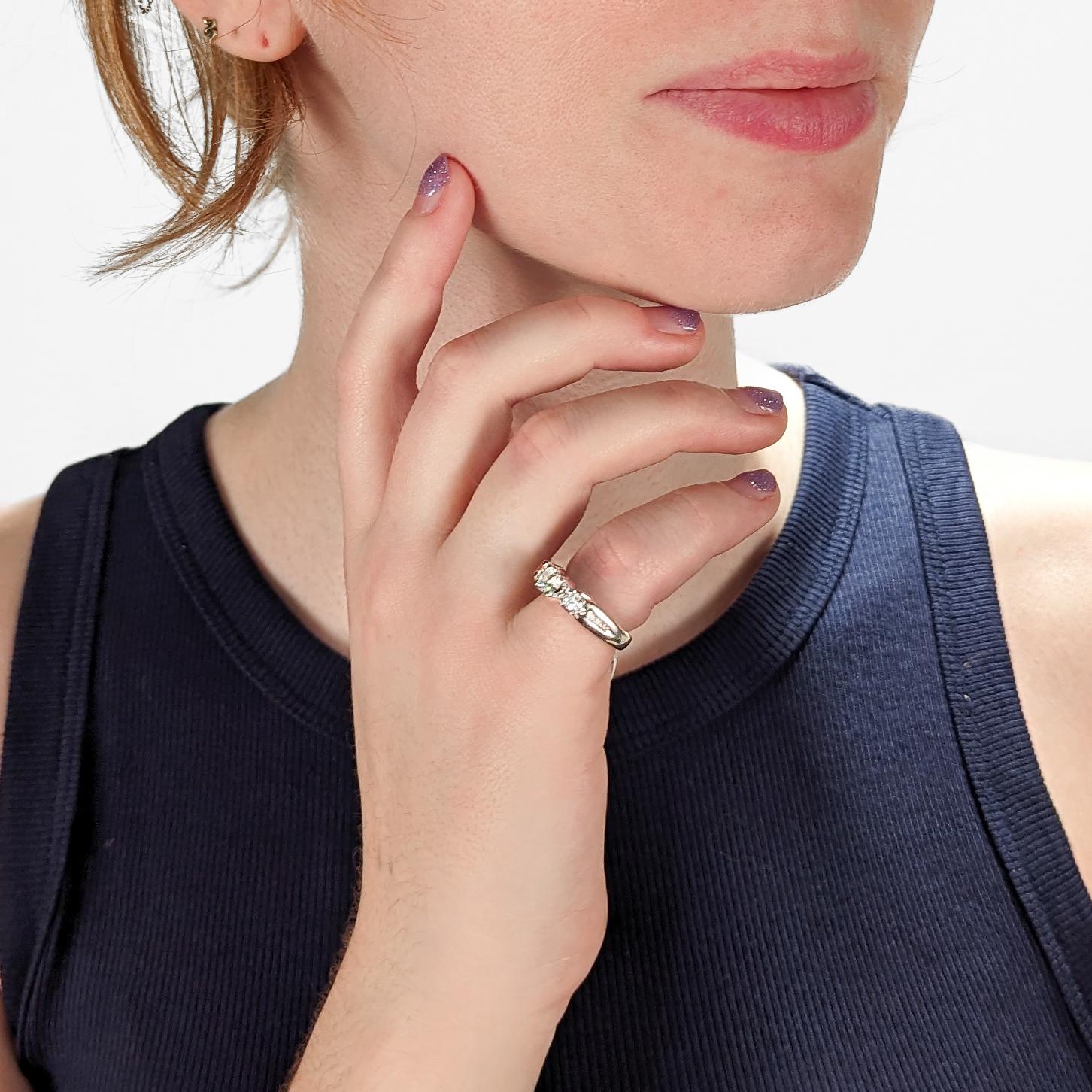 Une très belle bague en diamant.

Trois diamants ronds de taille brillant sont sertis au centre de la bague et flanqués de six diamants d'accentuation plus petits sertis sur les épaules d'une bague en or blanc 14k.

Pierre centrale : environ 0,35