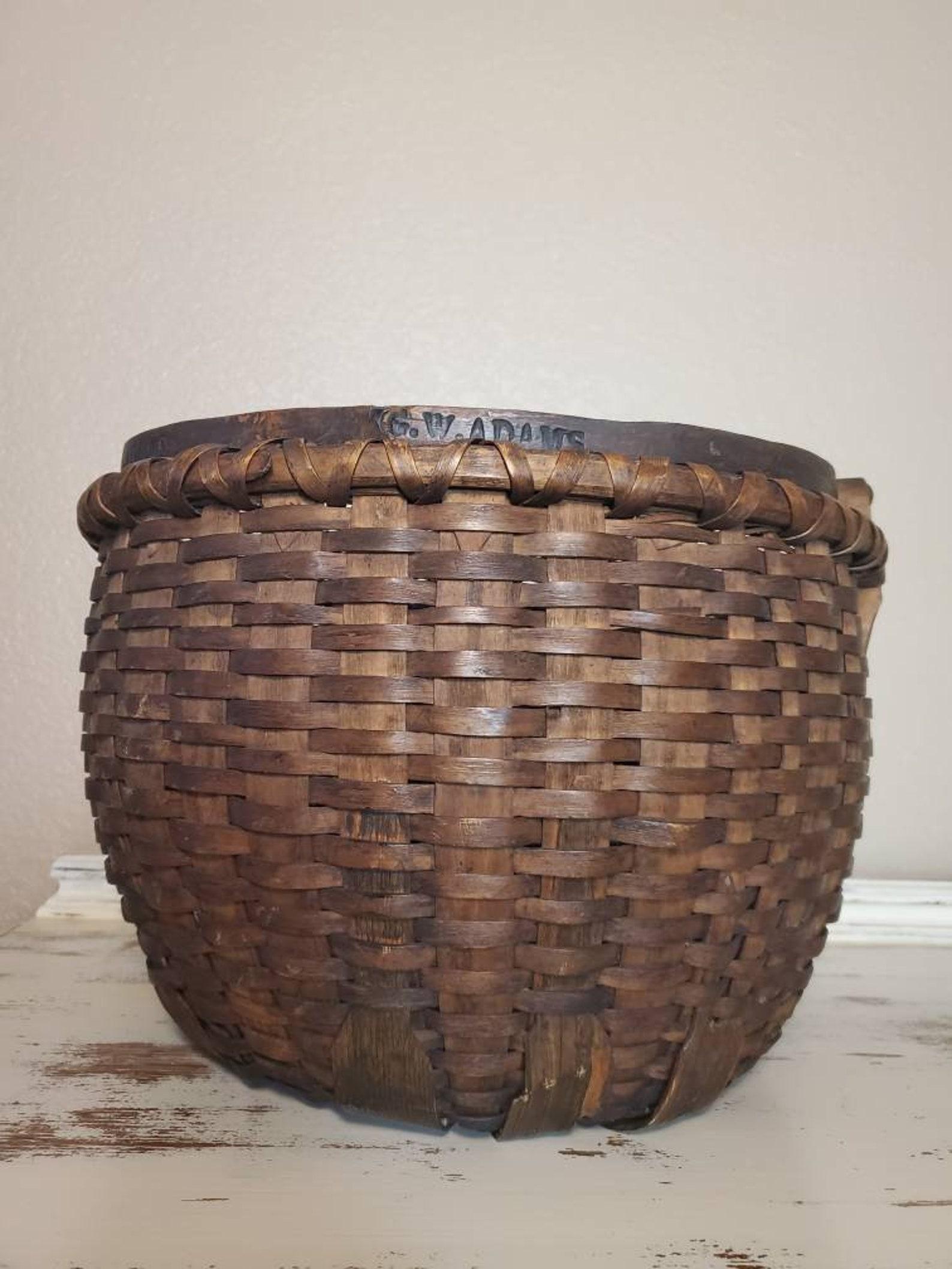 A beautiful large American stave woven splint basket from the 19th century, with a double rolled rim and a single swinging bentwood handle, signed G.W. Adams to both the handle and base. 

Gathering baskets like this were used to gather fruits,