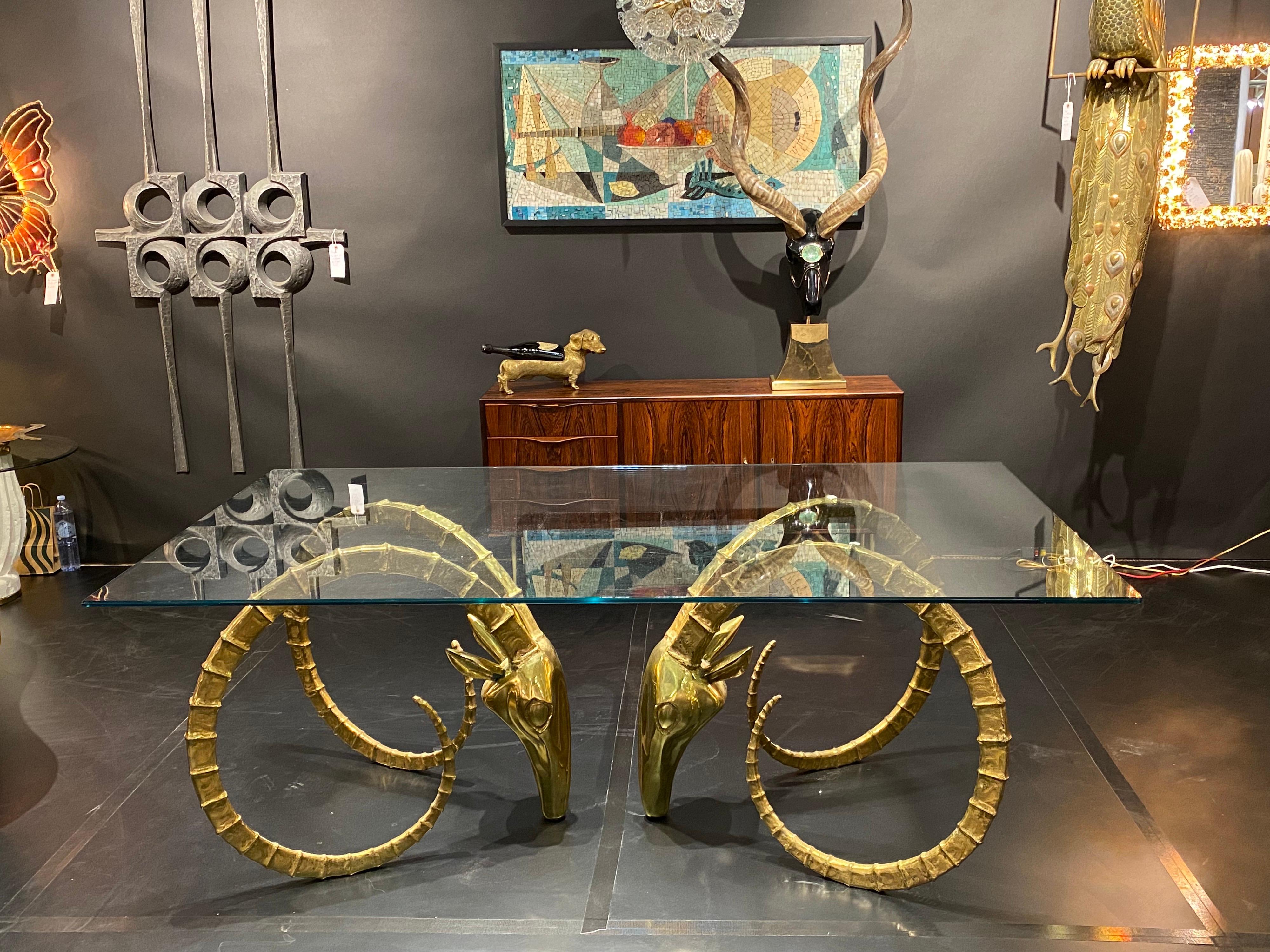 Signed 3/150 Alain Chervet brass Ibex dining table or desk. Glass top shown is 76” x 42” and not included. We suggest getting glass top locally in your desired size. It will hold much bigger and heavier glass top. Each base measures 28.5” high, 31”