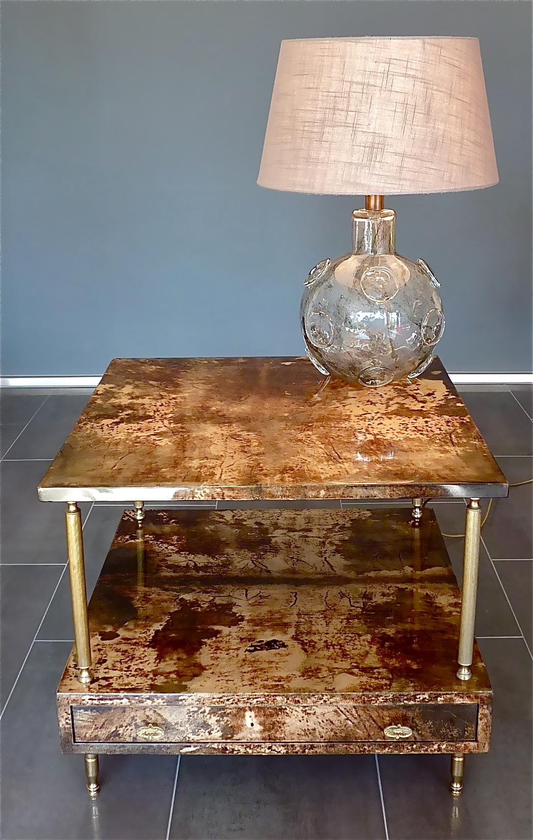 Great midcentury pair of signed Aldo Tura tables with vivid dark brown and caramel color parchment in combination with patinated brass, created in Milan, Italy circa 1950-1960. Each lacquered goatskin table which has a drawer can be used as end,