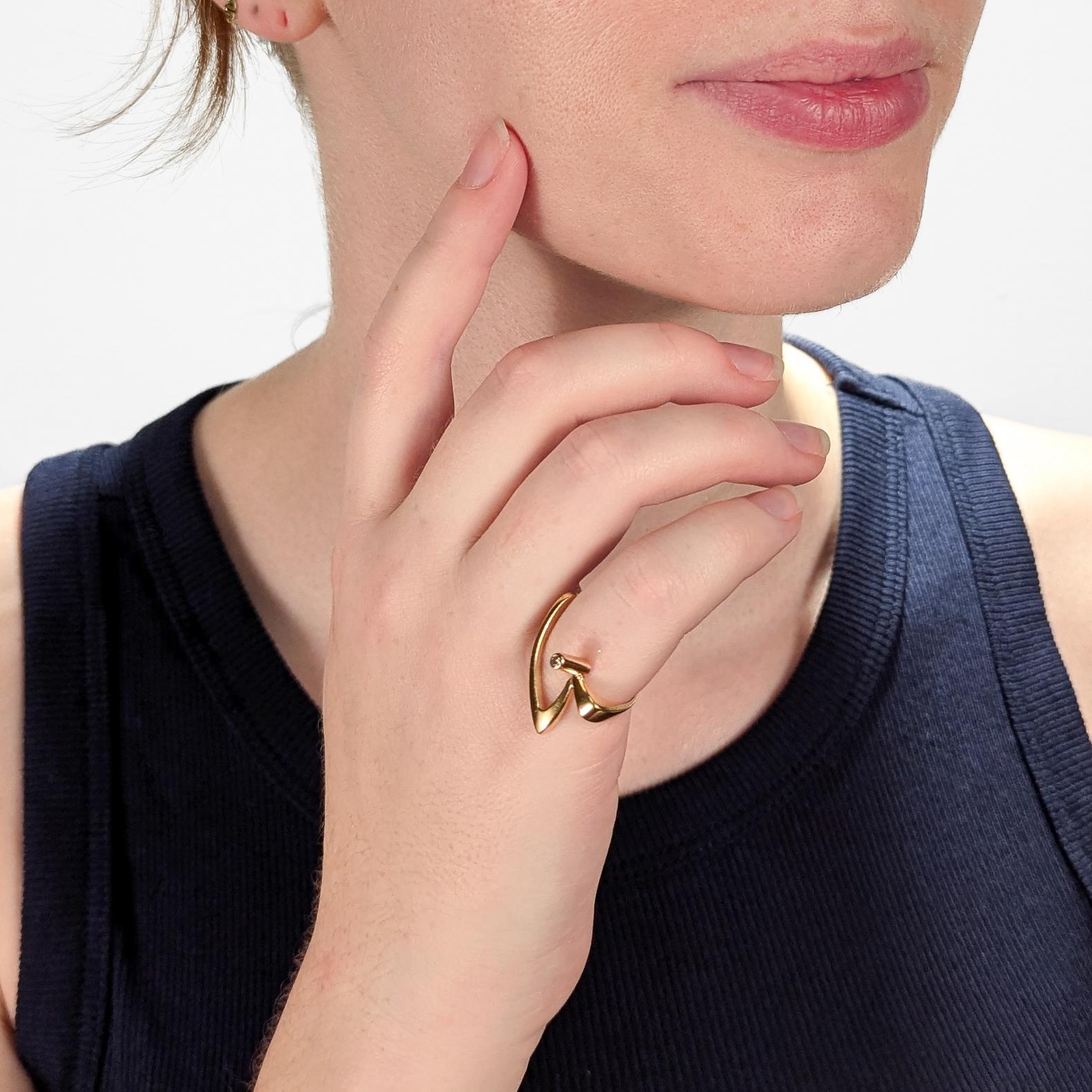 Anillo solitario modernista de oro y diamantes.

En oro amarillo de 18 quilates.

Por Alfred Karram Jr. (n. 1932 - m. 2017).

Con un engaste asimétrico angular y un diamante blanco de talla redonda engastado en tubo.

Marcado en el interior 18K /