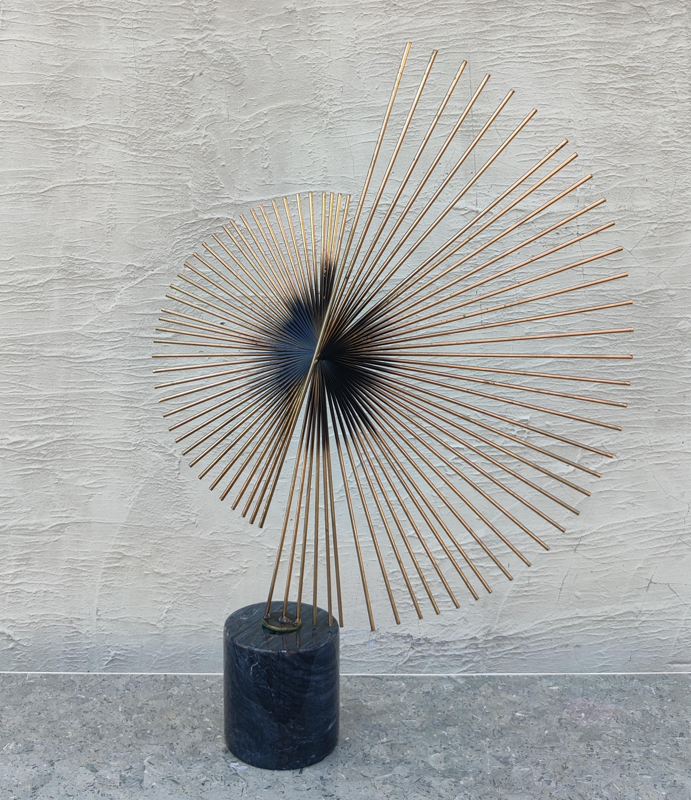 This stunning Curtis Jere sculpture was made in 1987, and features a superb and iconic design. Made of 40 long brass rods welded to each other across a center line, it forms an exaggerated spiral that catches your attention from every angle. This is