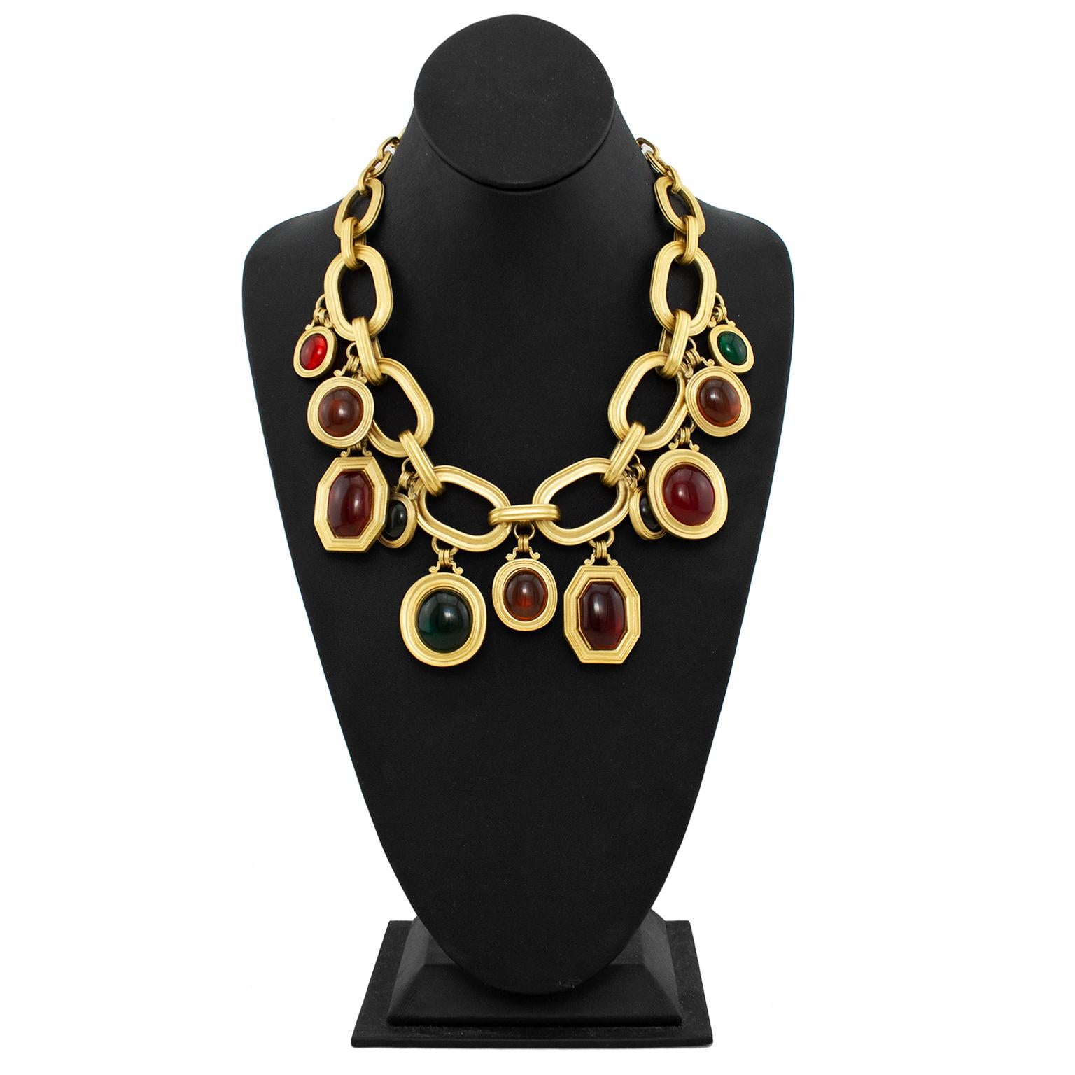 Very beautiful Yves Saint Laurent limited edition statement necklace from the 1980s. Pale matte gold metal large chain with 11 hanging pendants. The pendants vary in size in shape and are green, amber and red. Much of the YSL jewelry from this era