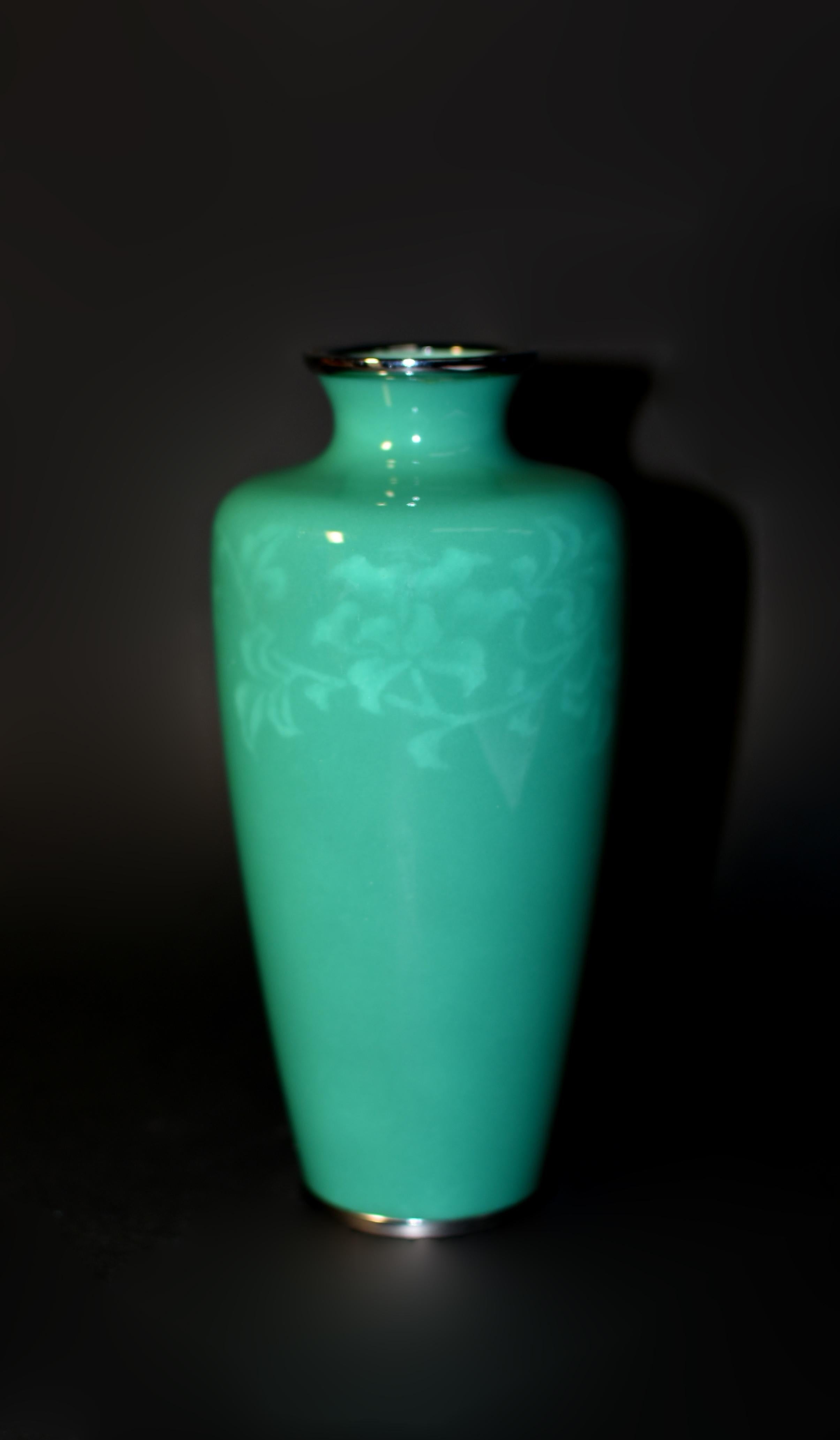 A masterpiece of Ando Jubei wireless cloisonné vase. In his signature green enamel, portraying an intricate arabesque design of a blooming clematis vine under the glaze. By removing wires that would otherwise hold the enamel before firing, Ando