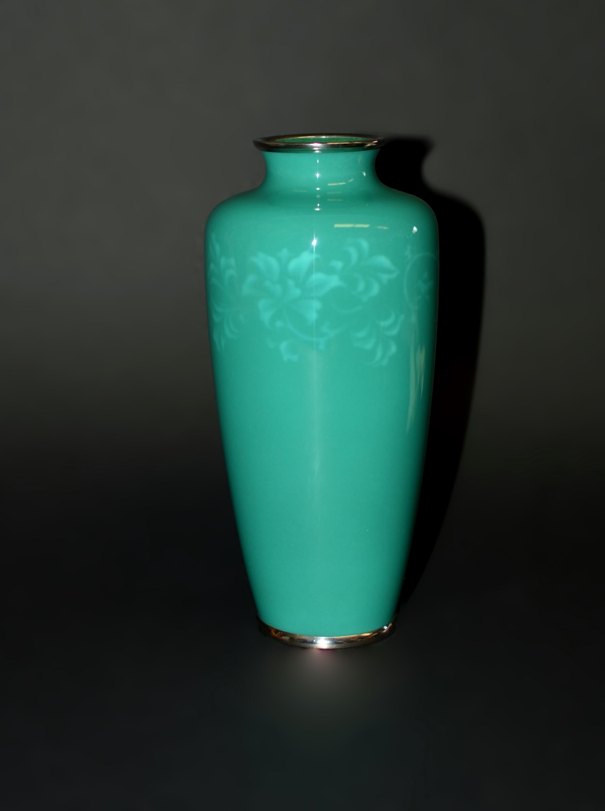 Uno squisito vaso cloisonné senza fili di Ando Jubei. Con il suo caratteristico smalto verde, raffigurante un intricato disegno arabesco di una vite di clematide in fiore sotto lo smalto. Sullo sfondo di Musen-jippo, Ando ha catturato la delicata