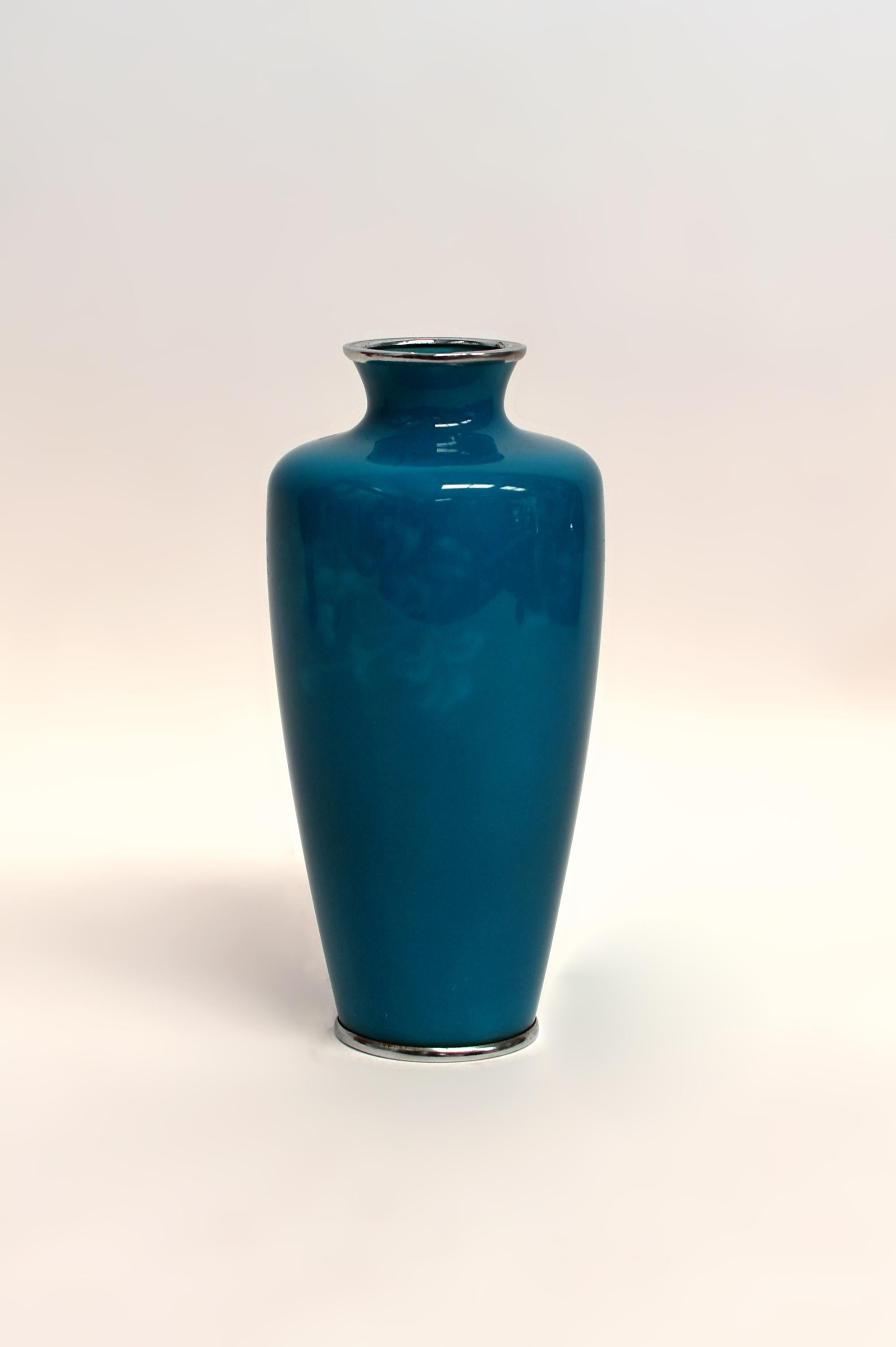 A masterpiece of Ando Jubei wireless cloisonné vase. This piece has a very unique color feature, it is a beautiful peacock blue in bright light and turns into a stunning cobalt blue in a darker environment. In the fantastic enamel, portraying an