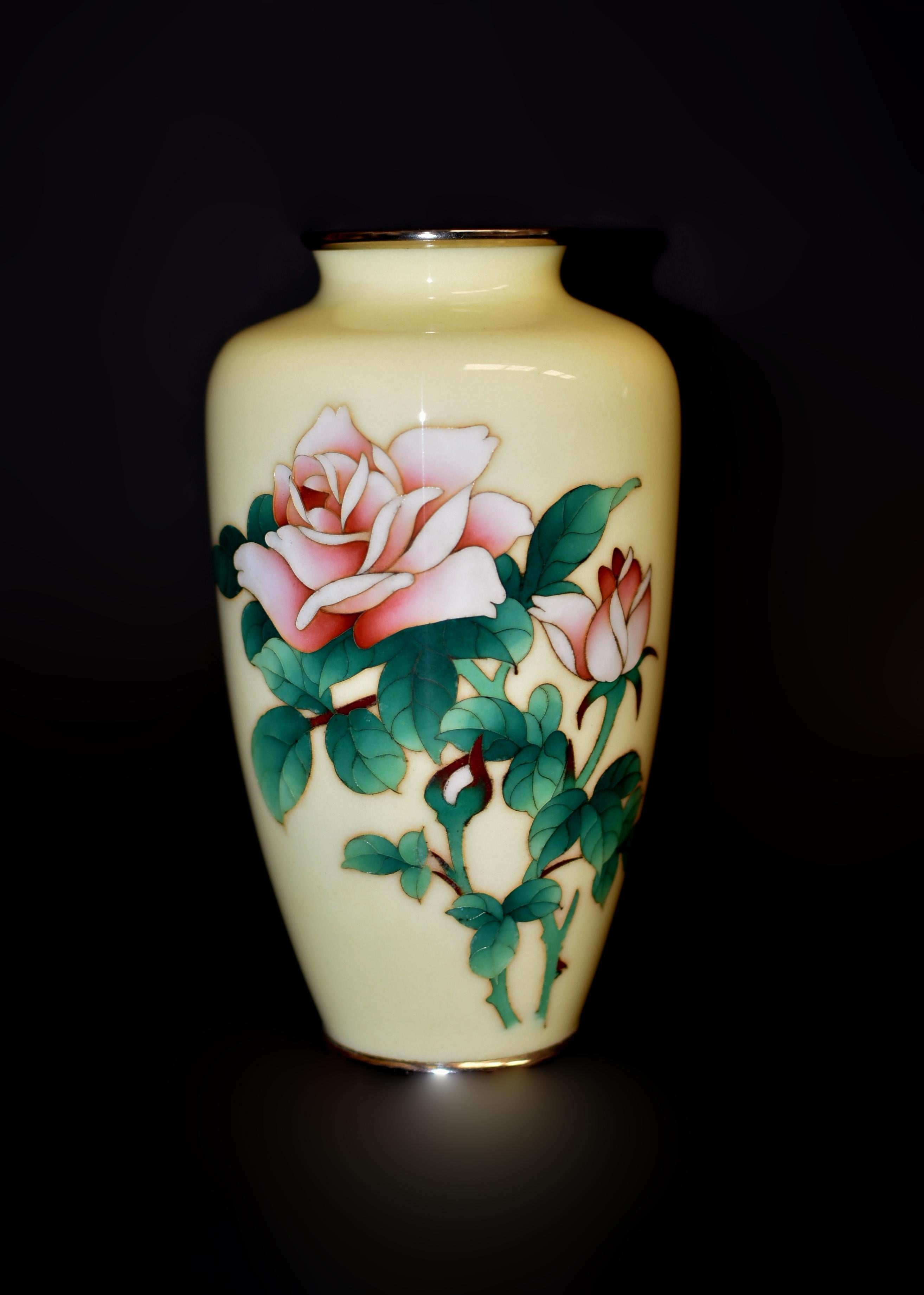 Superbe grand vase rose d'Ando Jubei (1876-1956) sur fond délicat de Musen-jippo jaune crème. De forme classique avec des rebords en métal argenté finis à la main. Deux roses hybrides de thé en fleurs et en boutons sont représentées par un rose