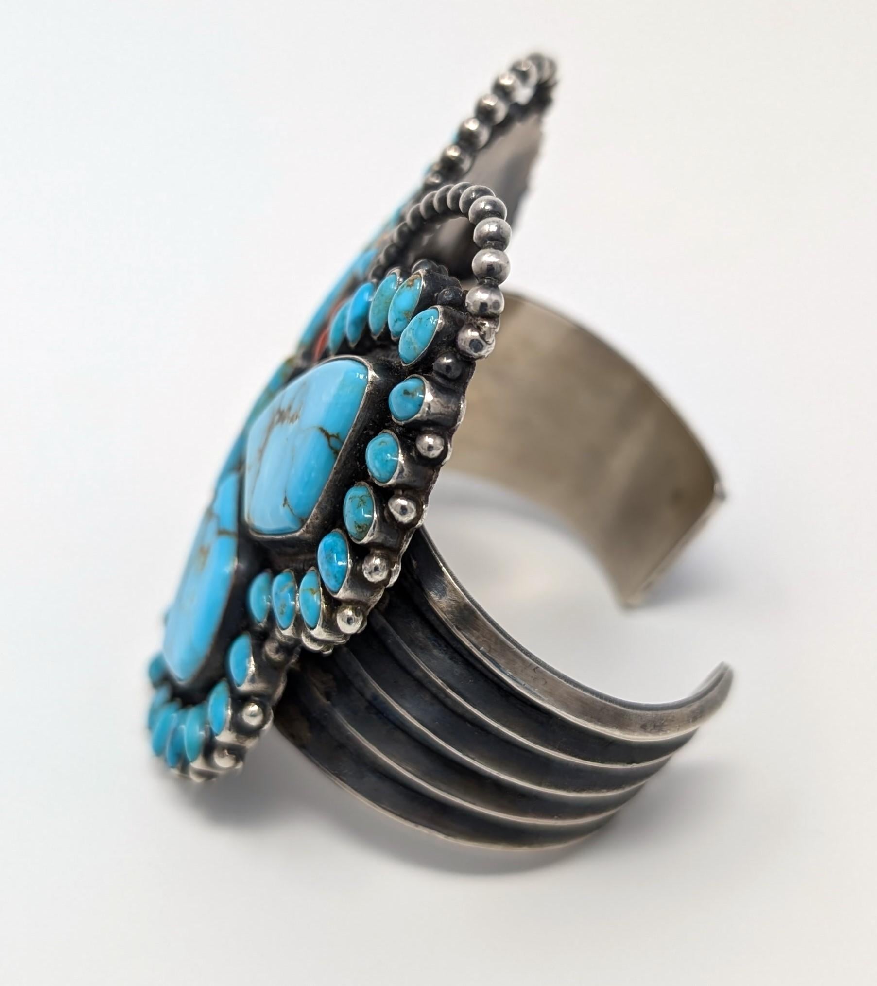 Stunning wide butterfly bracelet by Anthony Skeets, created in 925 sterling silver. Features turquoise and coral cabochons. Signed 