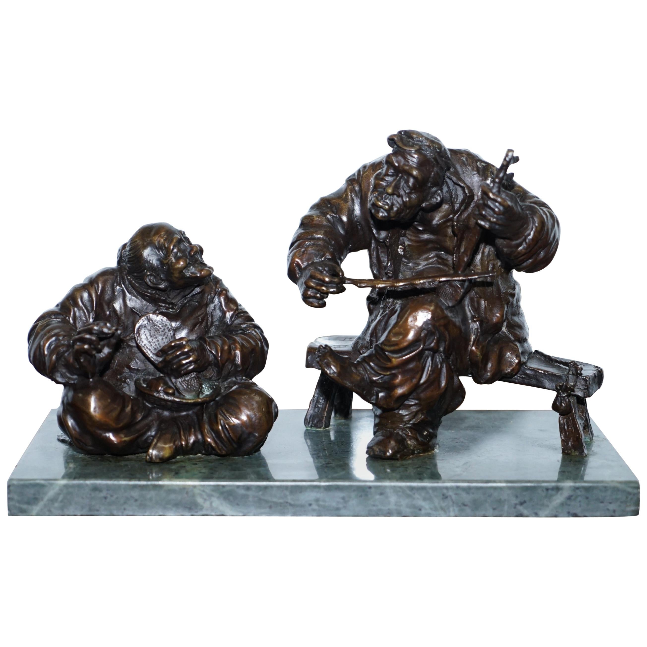 Statua in bronzo antico firmata di due uomini su una solida base in pietra ollare verde