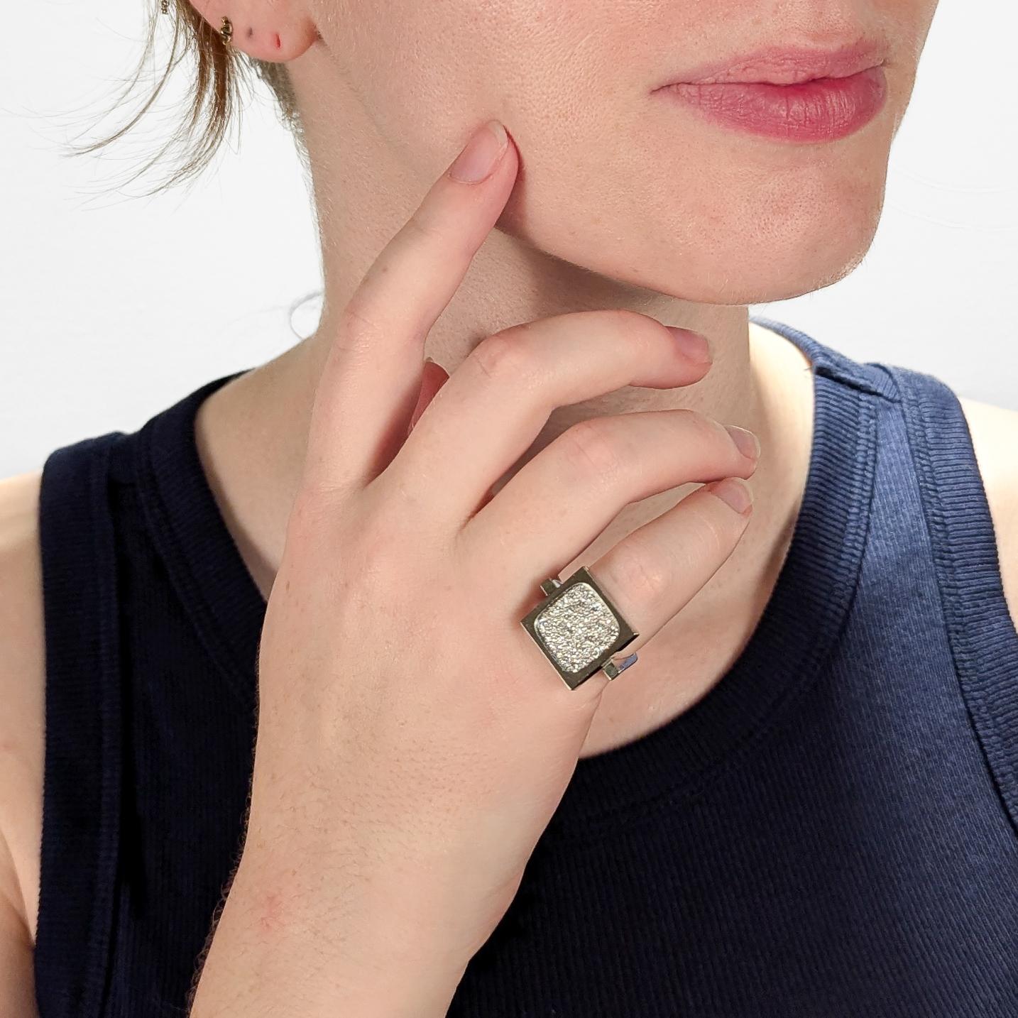 A fine signed Modernist ring.

By Armin Kurz, a highly regarded Swiss jeweler for over 7 decades.

In 18 karat white gold.

Set with pave diamonds on a square head with a tapered geometric shank.

Marked 750 & with an 'AK' maker's mark.

Simply a