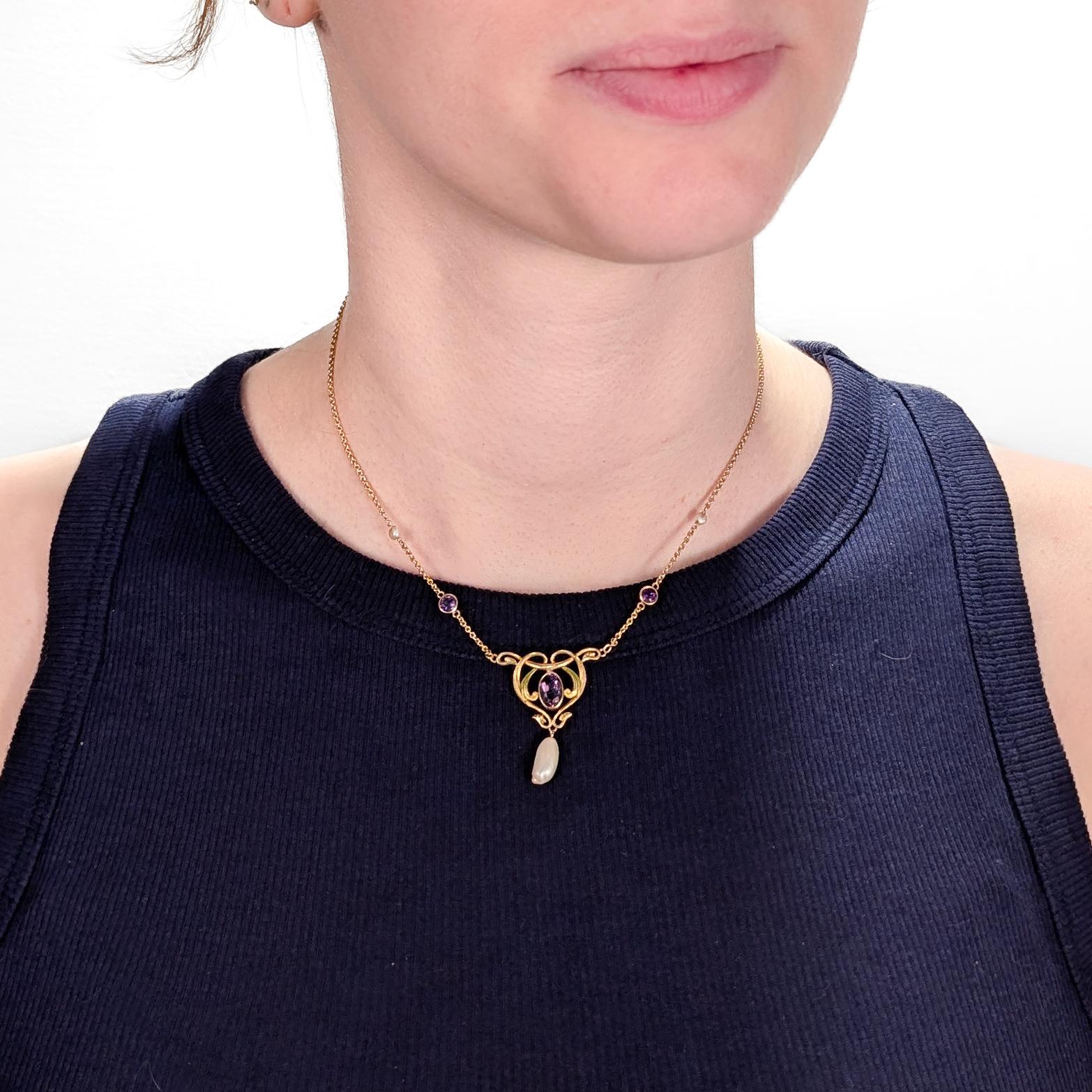 Un'antica collana di lavalier in stile Art Nouveau molto raffinata.

Da Krementz & Co.

In oro 14k.

Al centro un ciondolo con nastri smaltati, una gemma ametista ovale incastonata e una perla barocca a goccia. 

Il ciondolo è sospeso da una sottile