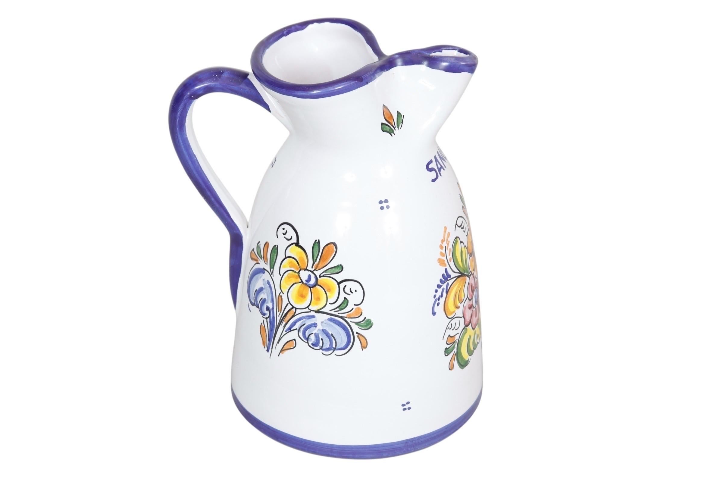 Pichet artisanal Talavera signé par Juan Antonio Froilan. Décoré d'un blanc éclatant avec une poignée bleu cobalt, une lèvre pincée bleue, une ligne autour de la base et le mot 