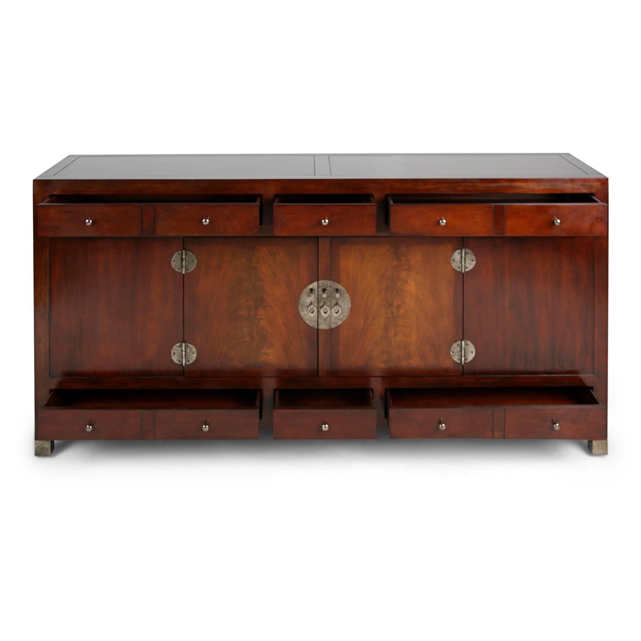 Extremely well crafted and impressive Ming style signed server by Baker. Fabricated from heavy mahogany and punctuated by metal hardware this expansive sideboard comprises of ten fitted drawers at the front with two doors. Both sides have hidden