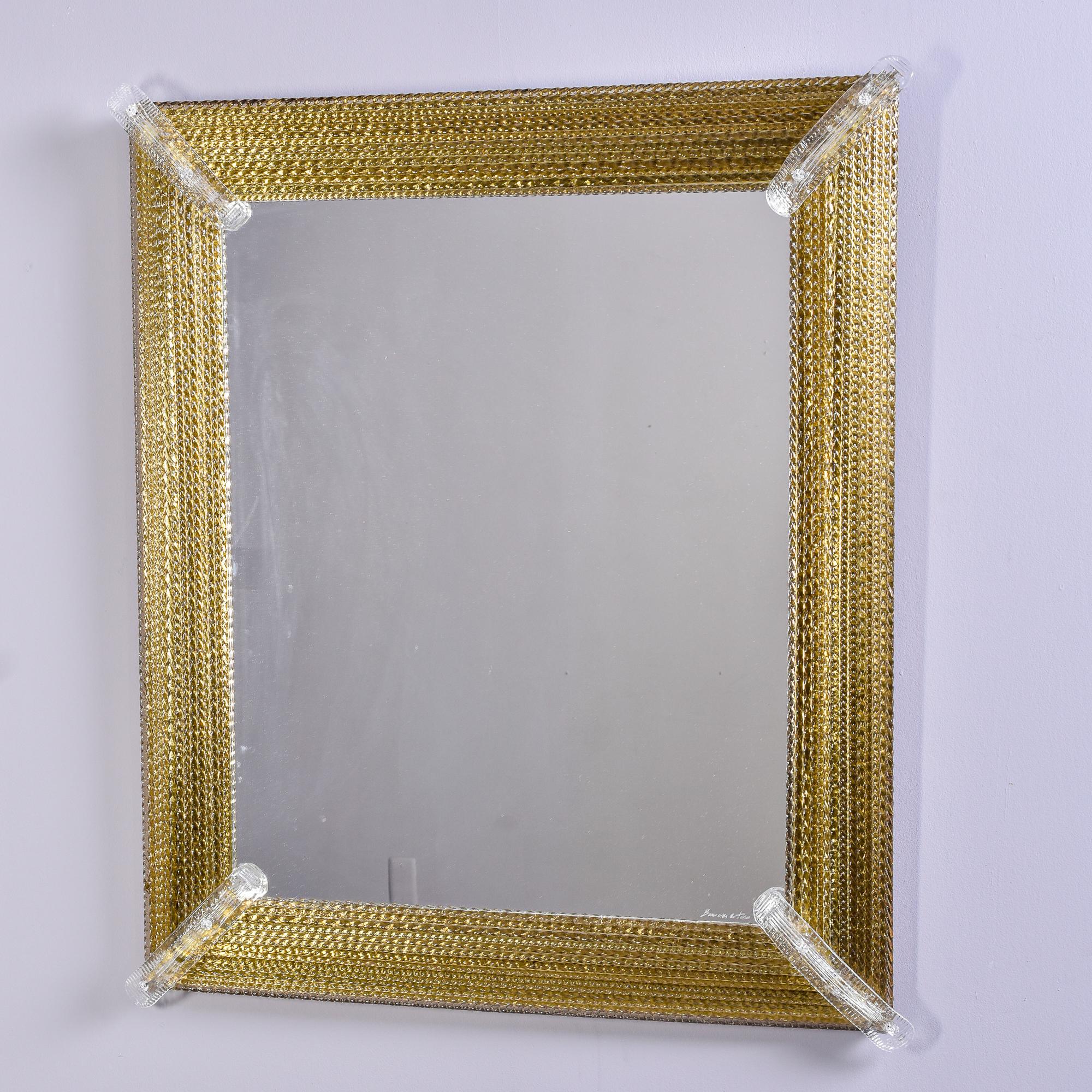 Circa 1980s signed Venetian mirror by Murano glass maker Barovier & Toso. Rectangular mirror with wood backing has a deep frame of multiple gold infused twisted glass rods and long, clear corner accents. Etched signature. Two mirrors of this size