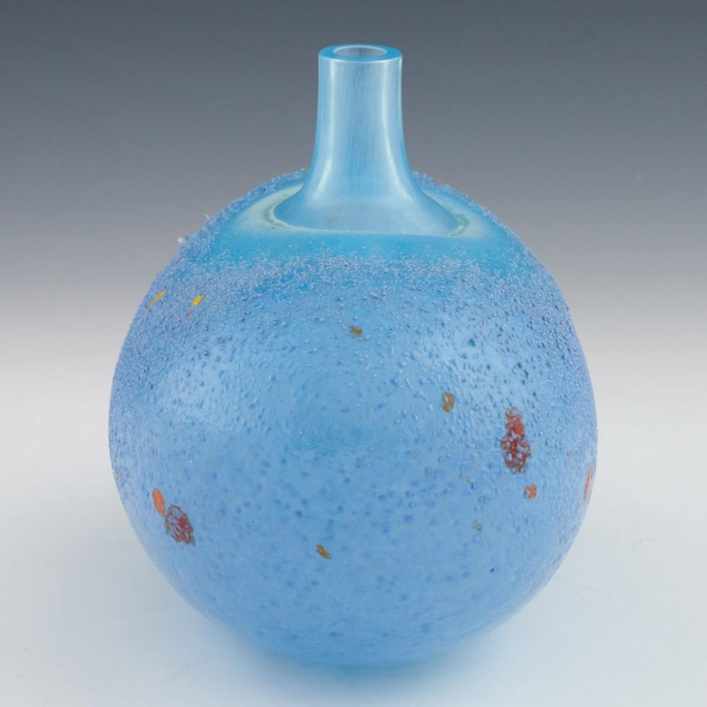 Heading : A late 20th century Kosta Boda egg vase.
Origin : Sweden
Bowl Features : A clear glass neck mottled in turquoise cased in blue glass with a pale lilac powdered glass frit coating dappled with red. orange and yellow
Marks : Incised on