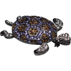 Broche de tortuga de cristal en tono plateado ennegrecido firmado con ámbar y piedra lavanda