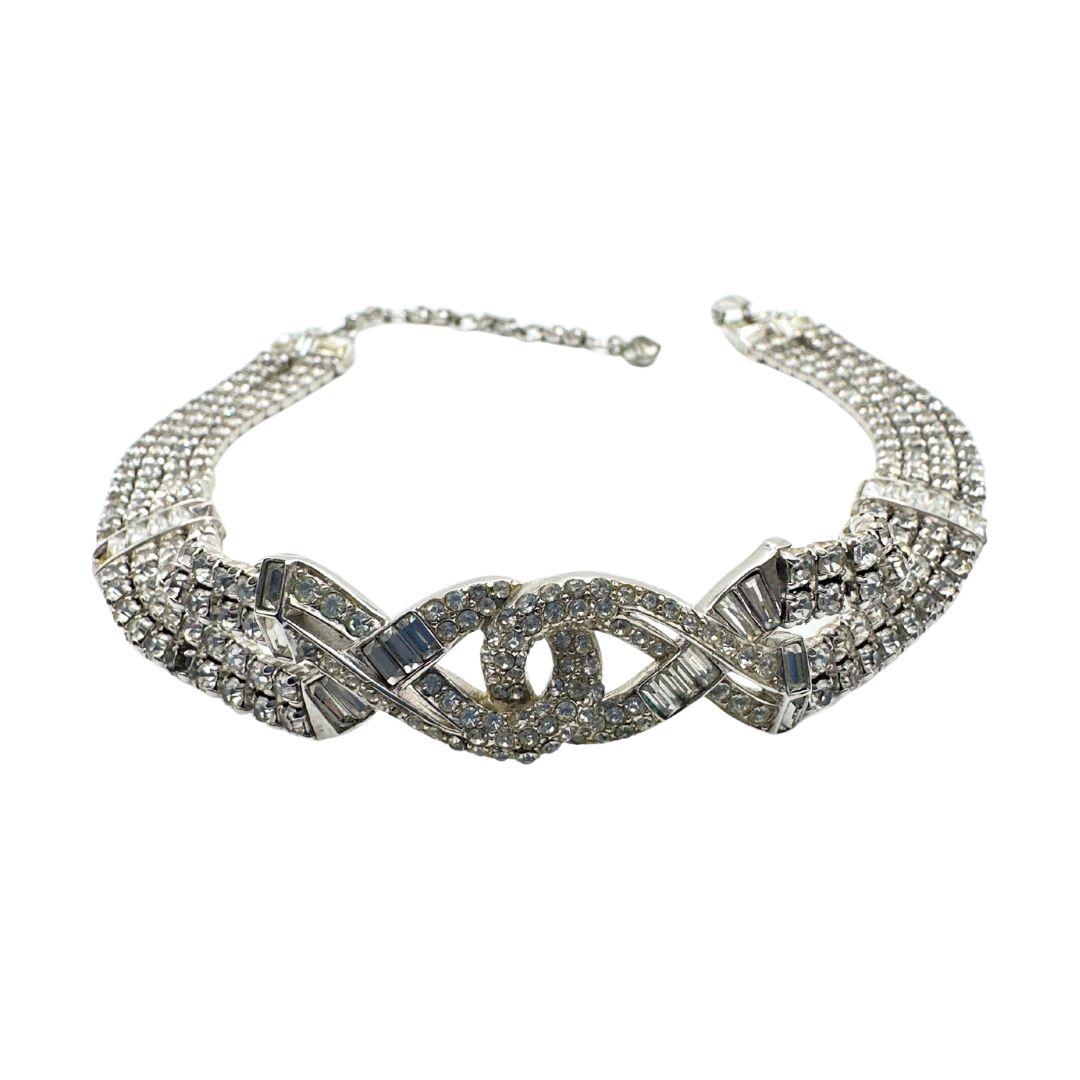 Length 15.25″

Step back in time and embrace the glamour of the Art Deco era with this exquisite signed Boucher rhinestone choker necklace. Meticulously crafted with attention to every detail, this dazzling piece captures the essence of vintage