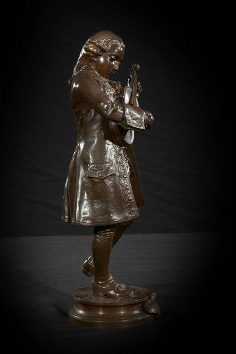 A signed bronze figure of a young mozart tuning a violin.
The whole on a circular base bearing the signature A. Gaudez. A central cartouche to the front engraved Gaudez Hors Concours.

Adrien Etienne Gaudez was born in Lyon 1845 and died in