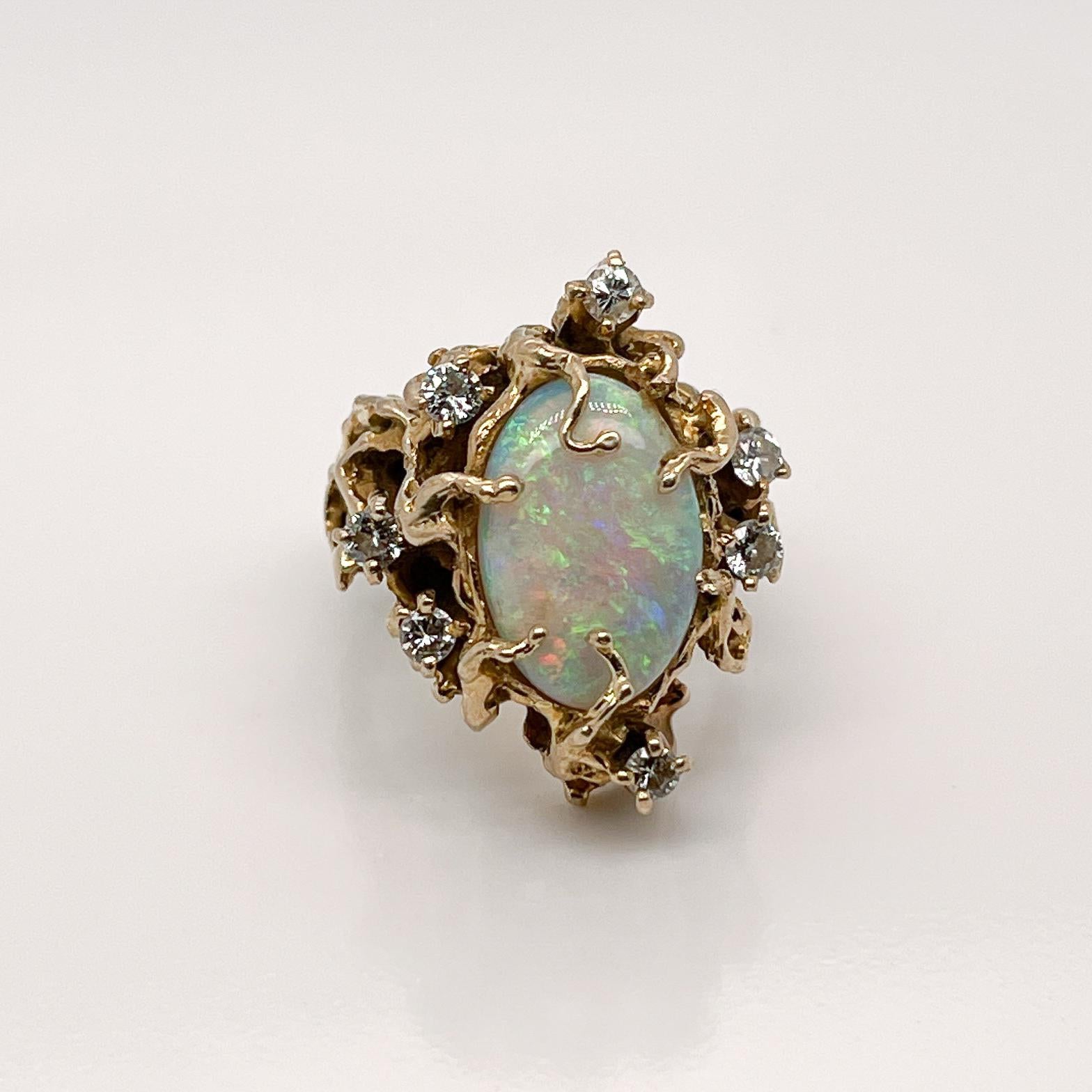 A very fine signed Brutalist opal and diamond ring.

With a large oval opal cabochon prong set in an organic, cast 14k gold setting. 

The opal is framed by seven small prong set round brilliant diamonds.

Simply a wonderful Brutalist ring!